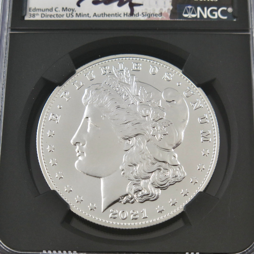2021 Morgan Silver Dollar commemorative coin in NGC MS70 grade, signed by Edmund Moy, displayed on a black background.