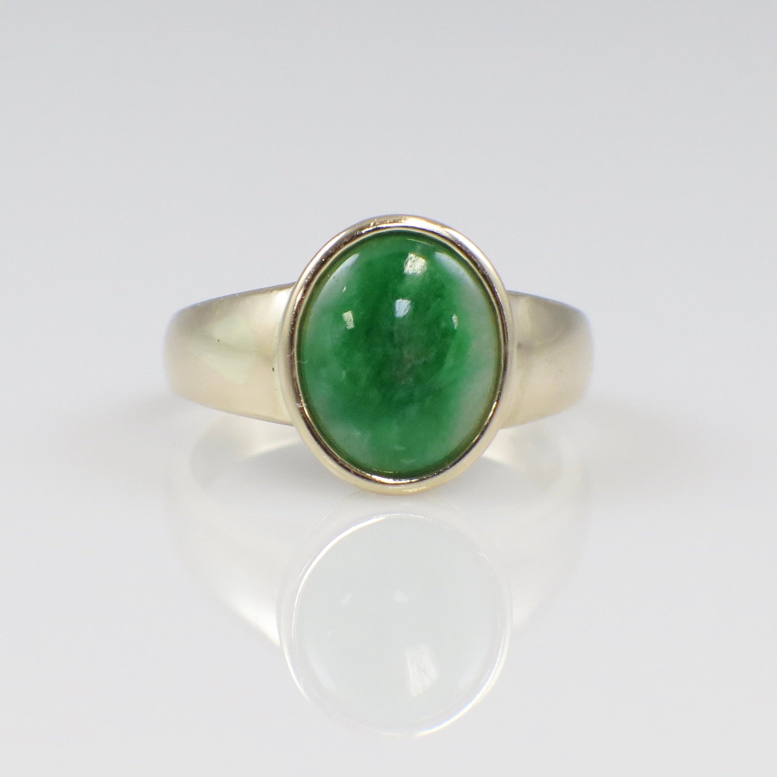14K yellow gold jade ring featuring an oval cabochon bezel-set green jade stone, size 6.75, by Black Market LLC.