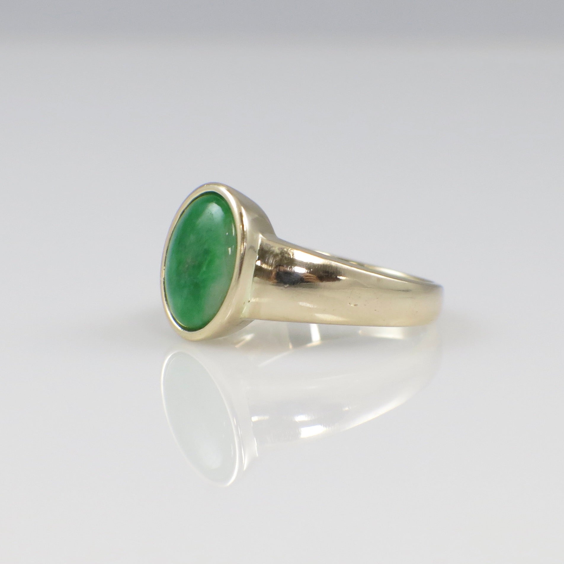 14K yellow gold jade ring featuring an oval cabochon bezel-set jade stone, size 6.75, by Black Market LLC.
