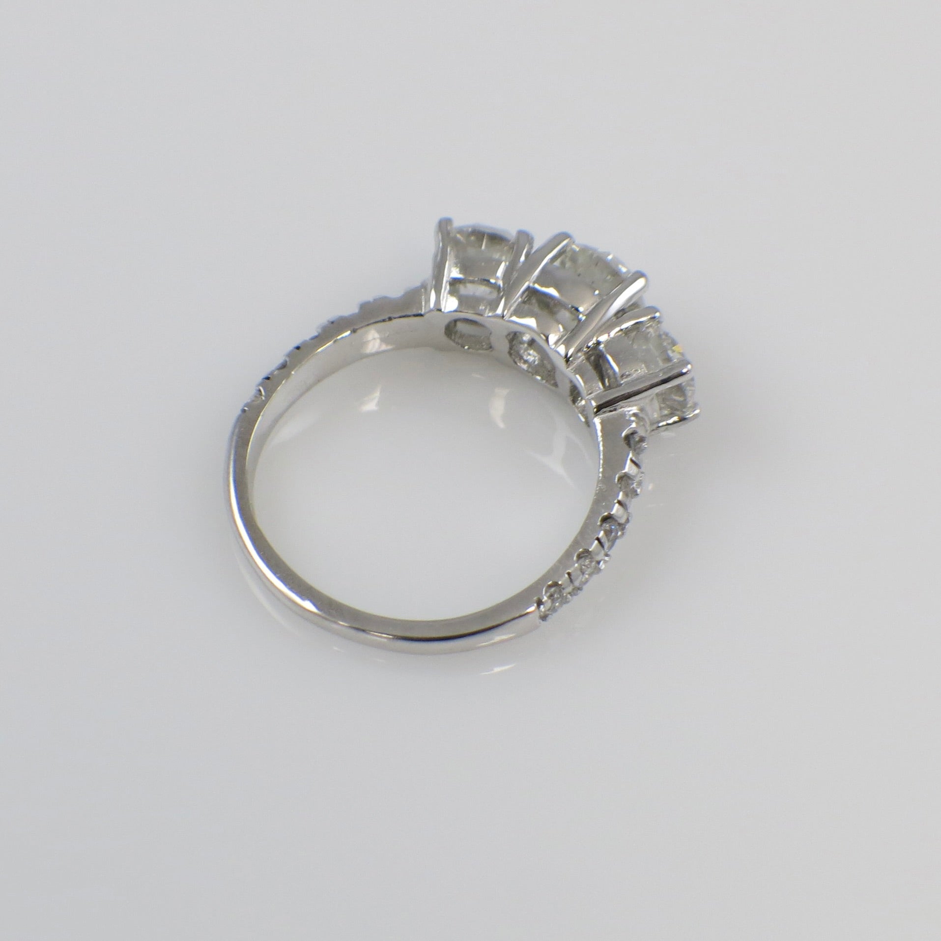 Vintage 18K white gold three-stone diamond engagement ring with 1.92 CTW from Lillian James Bridal, showcasing sparkling diamonds.