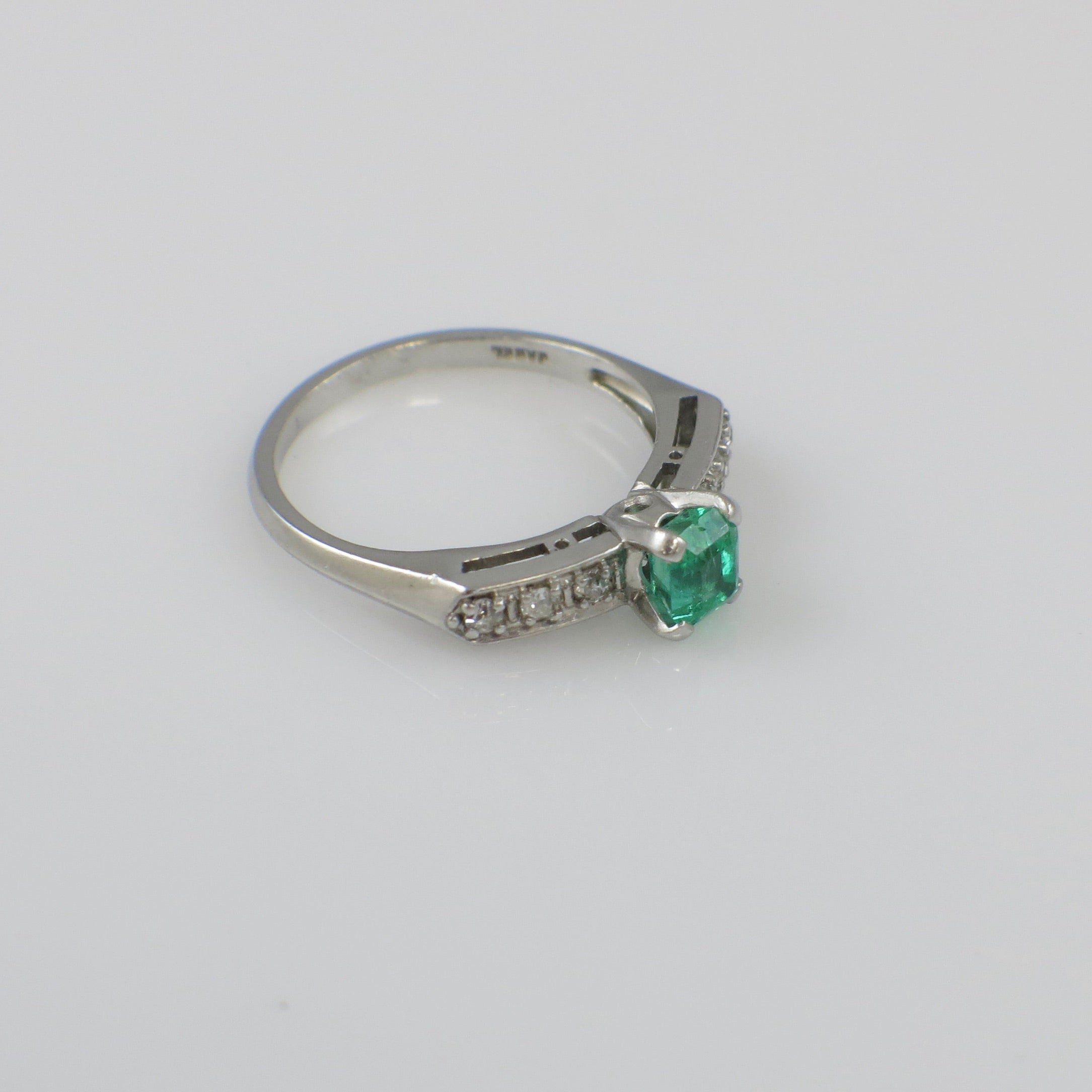 Vintage Art Deco emerald ring with platinum band and diamond accents, circa 1930s, featuring intricate design details.