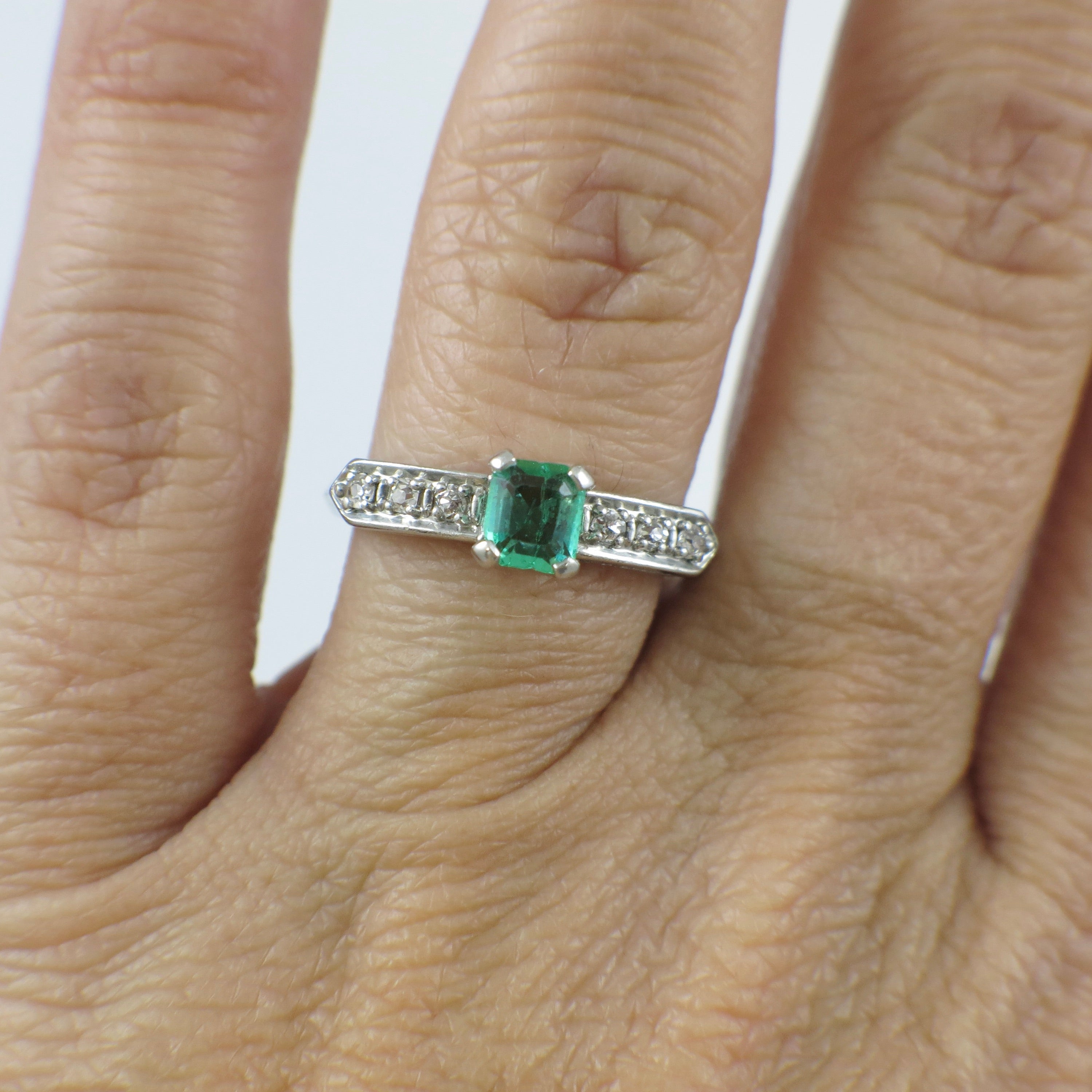 Vintage Art Deco emerald platinum ring with diamond accents, circa 1930s, featuring intricate design and fine craftsmanship.
