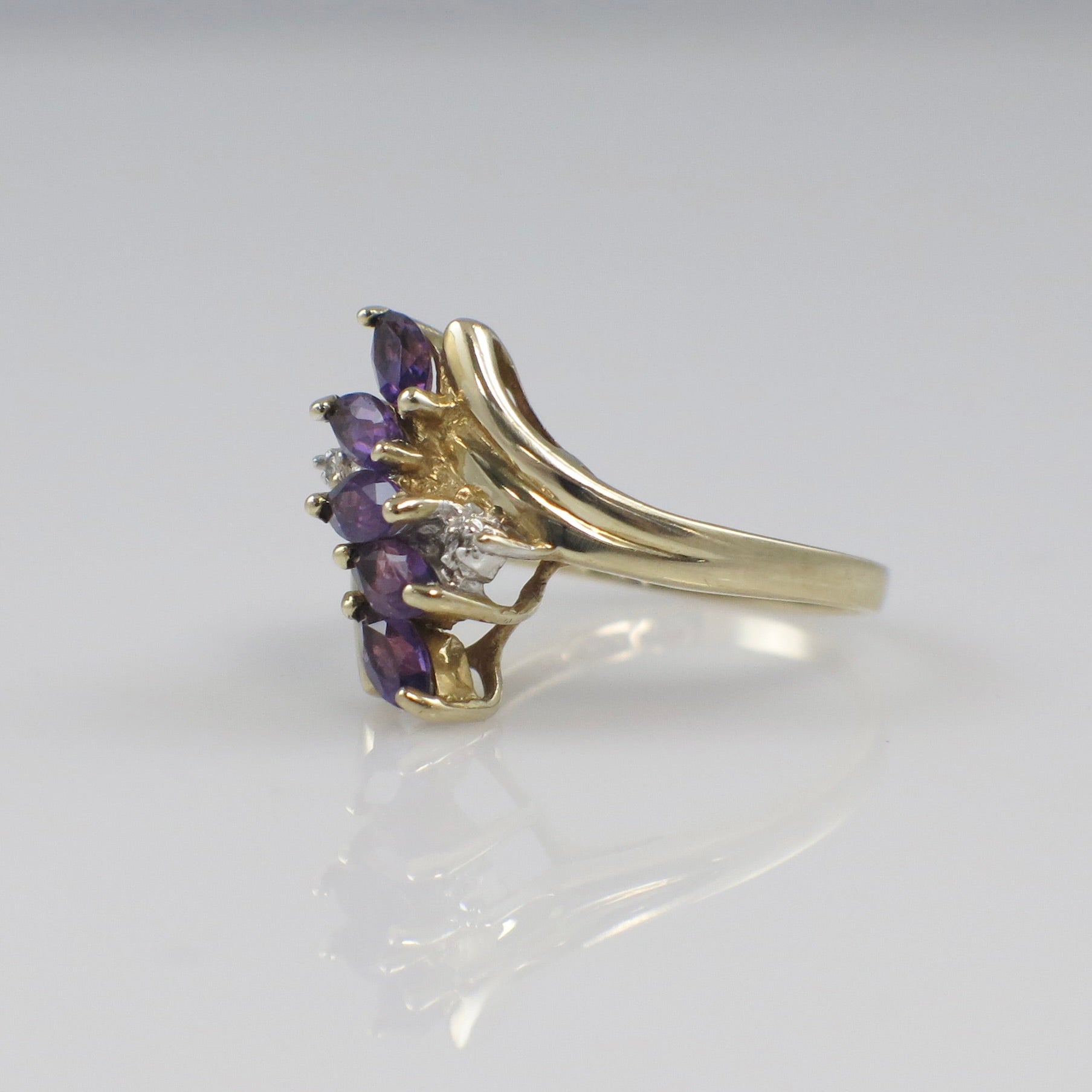Yellow gold amethyst marquise cluster ring with diamond accents, featuring a detailed design and elegant craftsmanship.