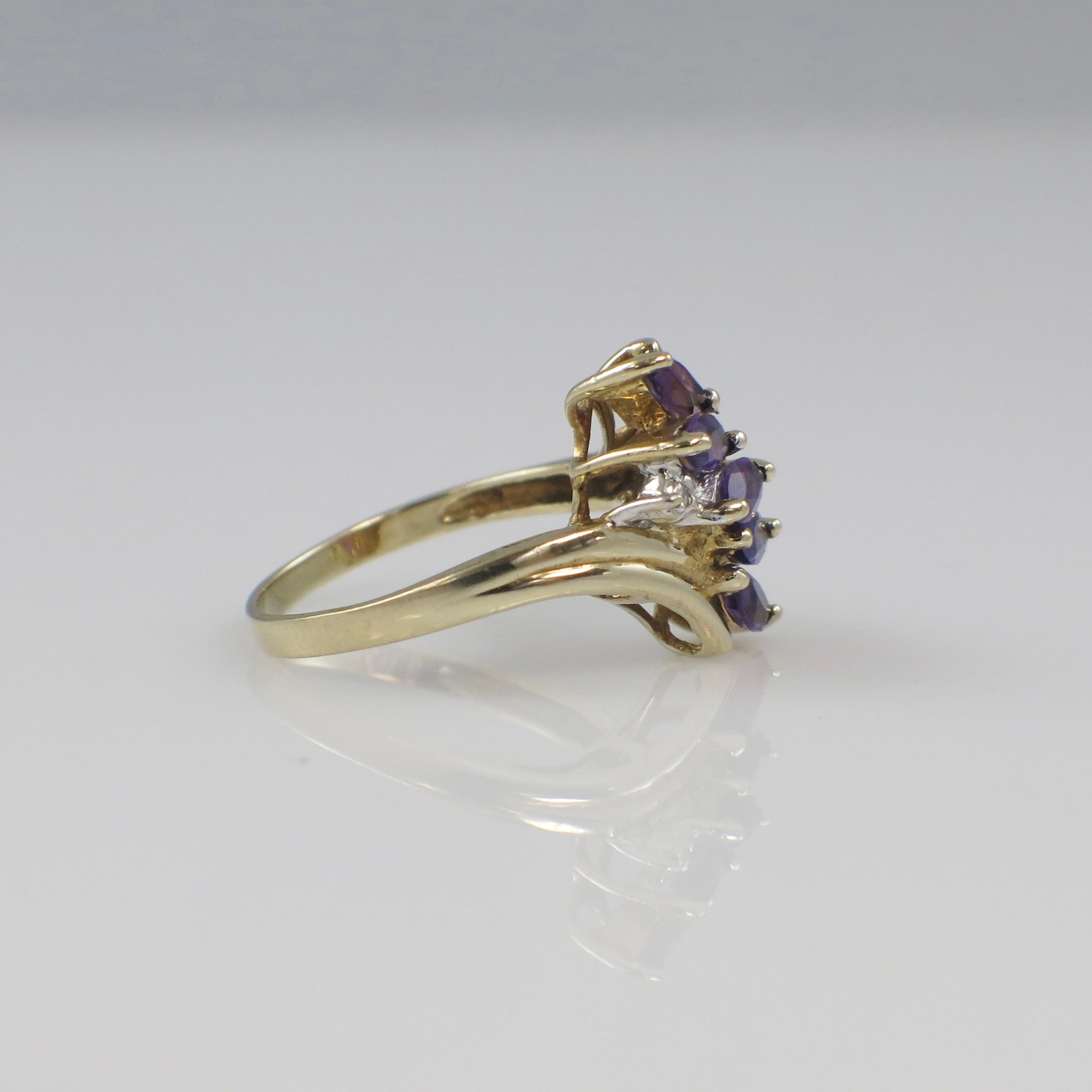 10K yellow gold amethyst marquise cluster ring with diamond accents, showcasing a vibrant purple gemstone and sparkling details.