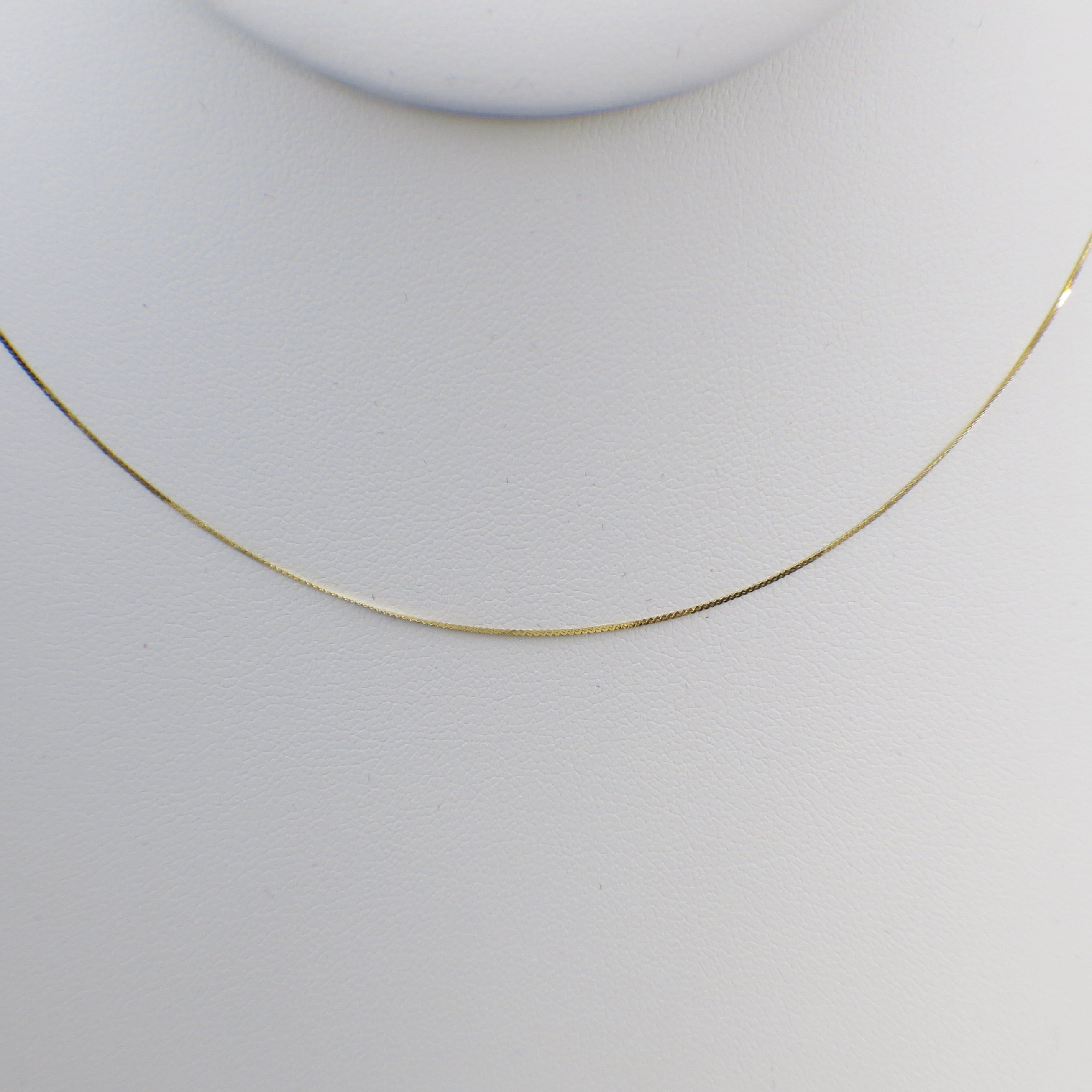 14K yellow gold serpentine chain necklace, 18 inches long with 0.5mm thickness, featuring a sleek, twisting design.