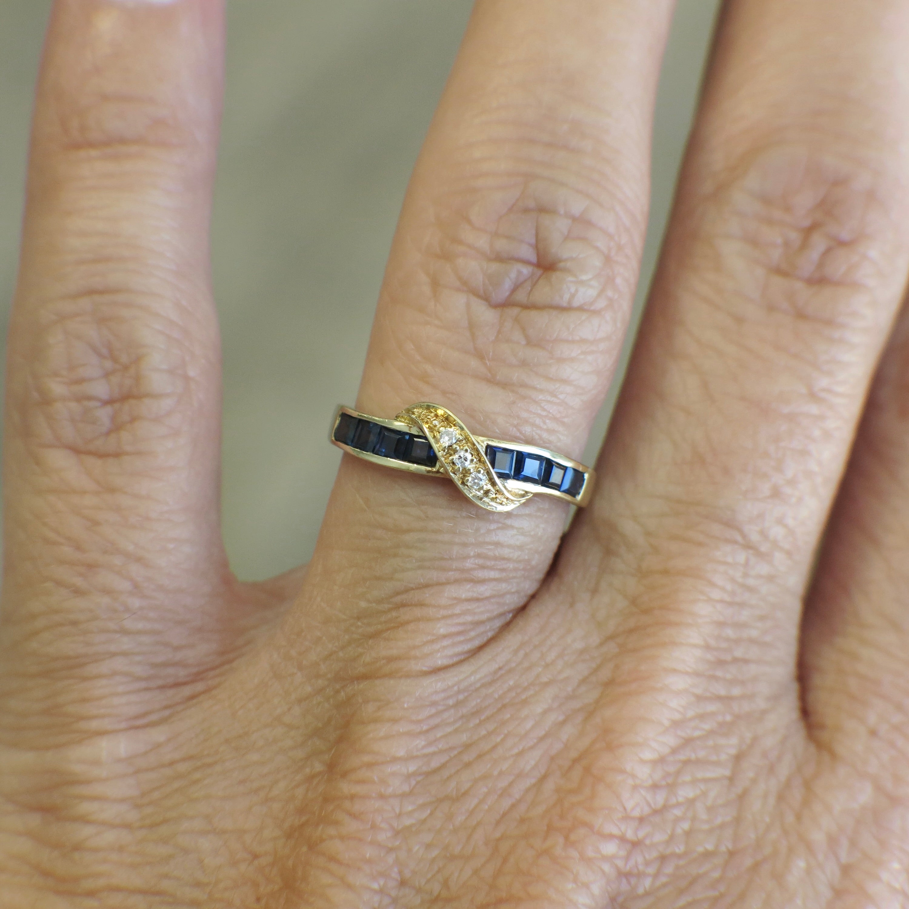 Vintage 14K yellow gold sapphire and diamond bypass ring with elegant design, crafted by Black Market LLC.