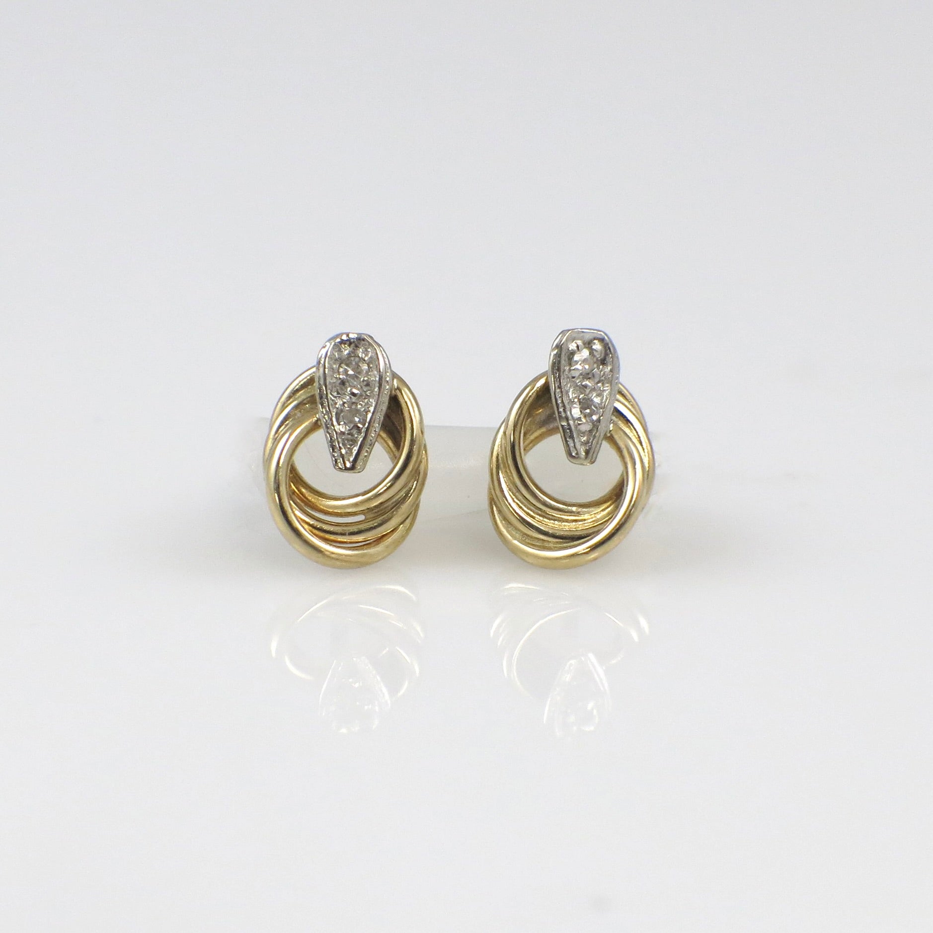 Vintage 14K two-tone gold diamond interlocking stud earrings with intricate design, from Black Market LLC.