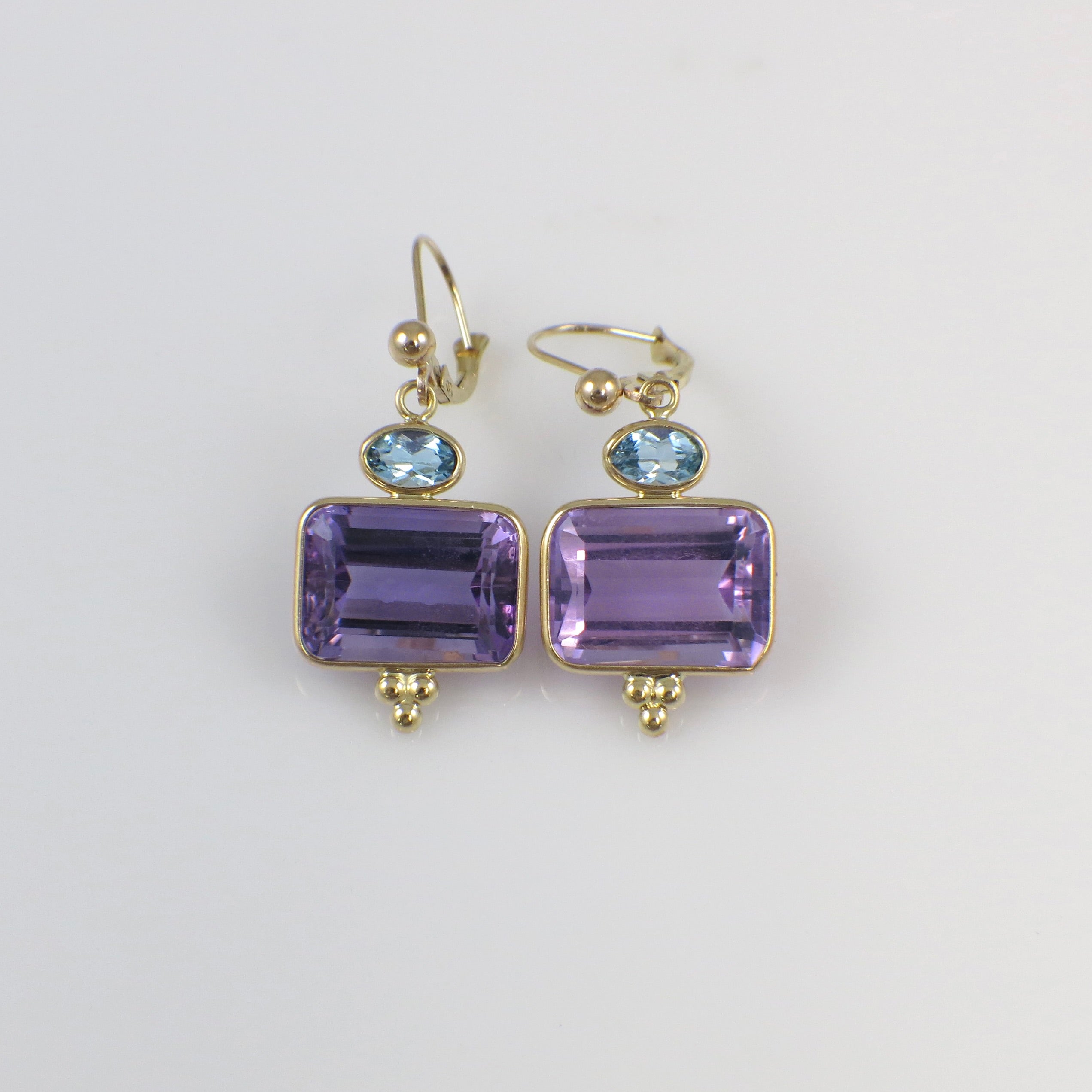 Vintage 14K yellow gold drop earrings with amethyst and topaz gemstones, featuring elegant dangling design.
