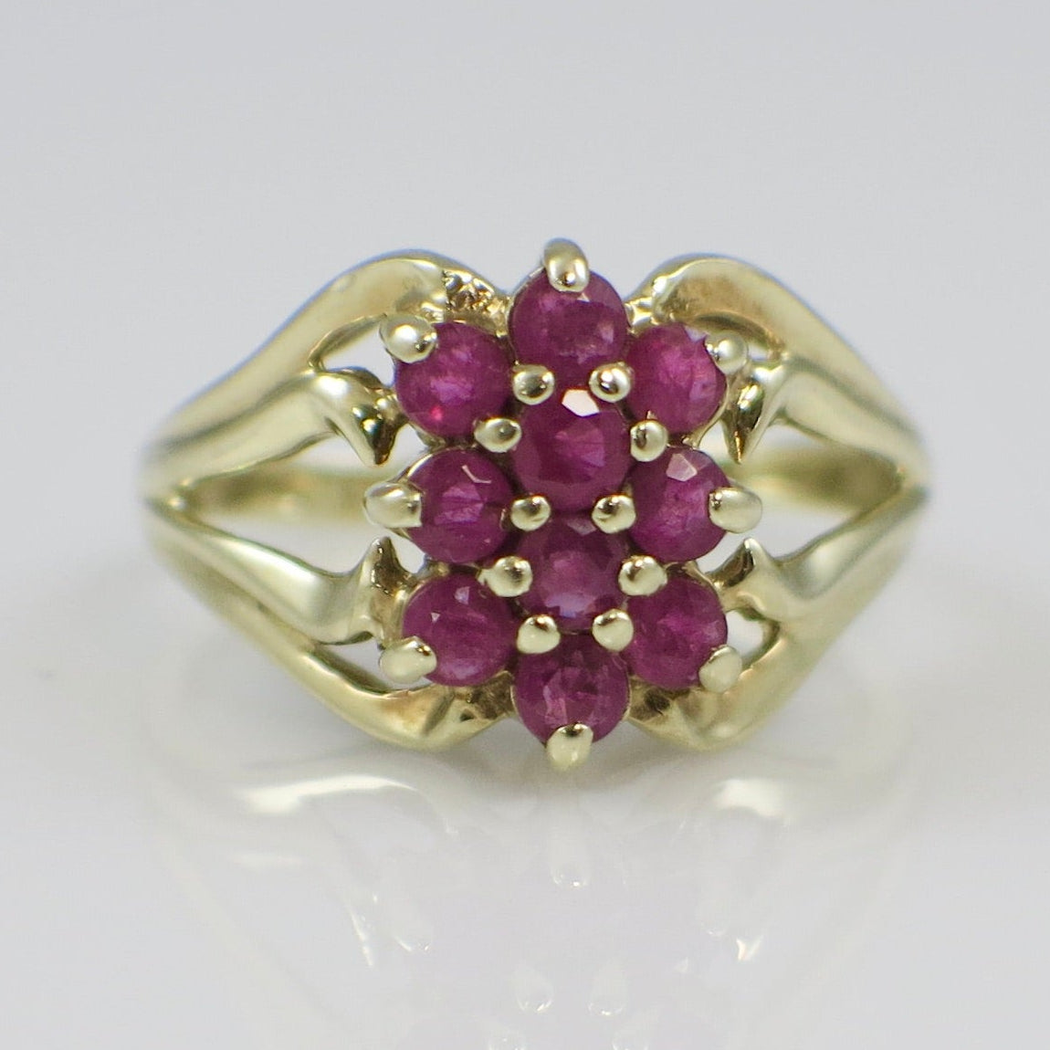 Gold ring with red gemstones on a white background