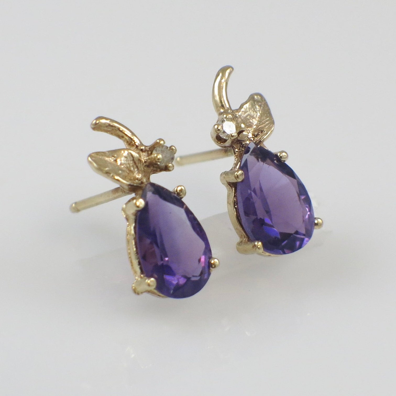 Vintage 14K gold amethyst and diamond stud earrings with classic design, featuring purple gemstones and sparkling accents.