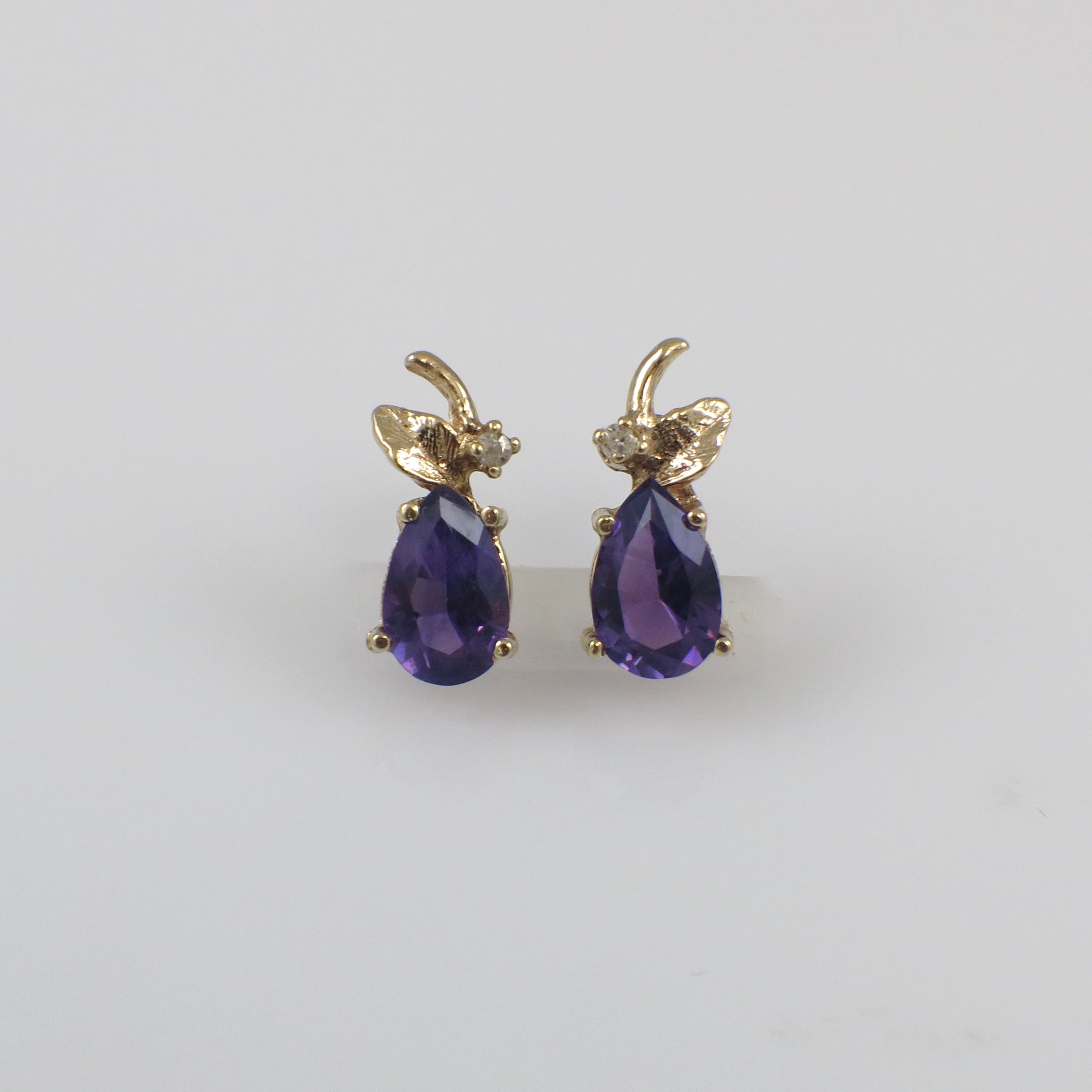 Vintage 14K gold amethyst and diamond stud earrings with a classic design, featuring purple gemstones and sparkling accents.