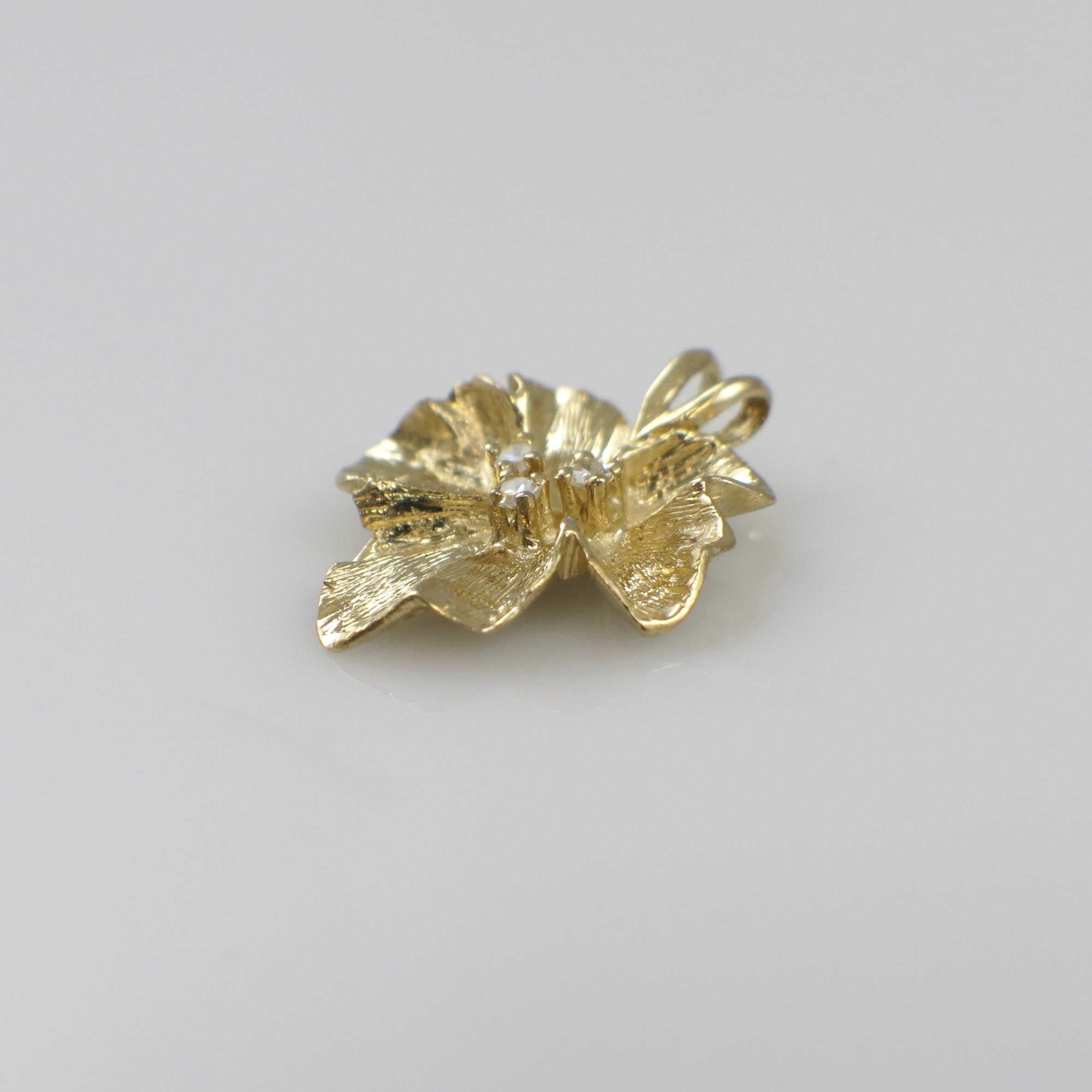 Vintage 14K yellow gold diamond floral pendant necklace with intricate flower design and sparkling diamonds.