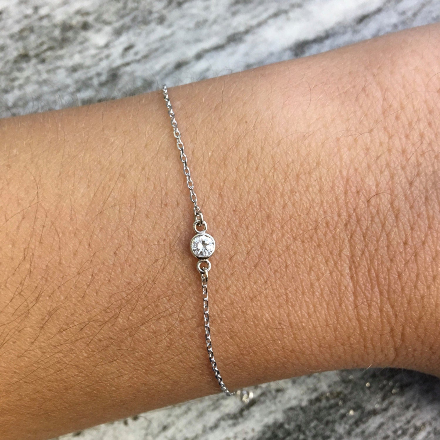 14K yellow gold diamond bezel bracelet by Black Market LLC, dainty layering jewelry with 0.10 CT diamonds on a slim bracelet.