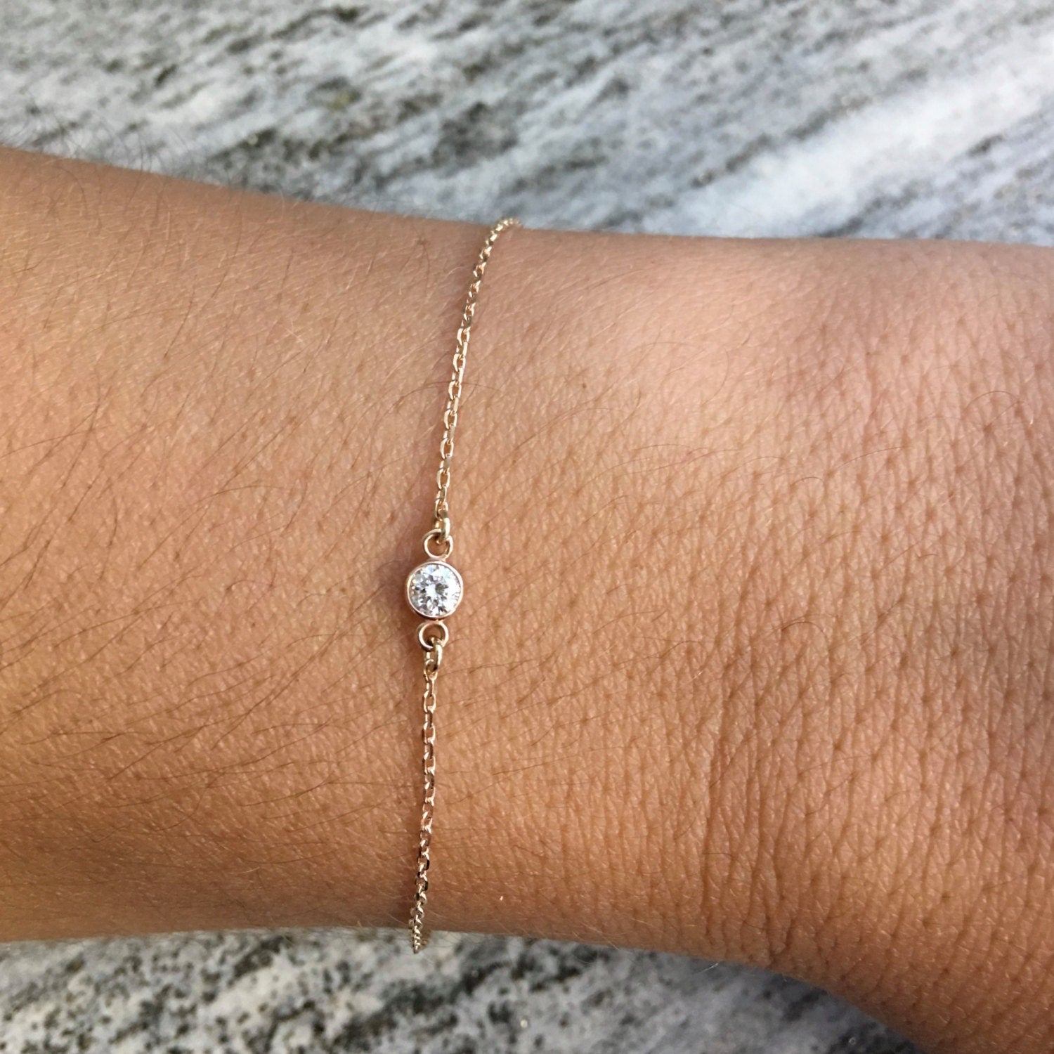14K gold diamond bezel bracelet by Black Market LLC featuring dainty layering design with 0.10 CT diamonds.