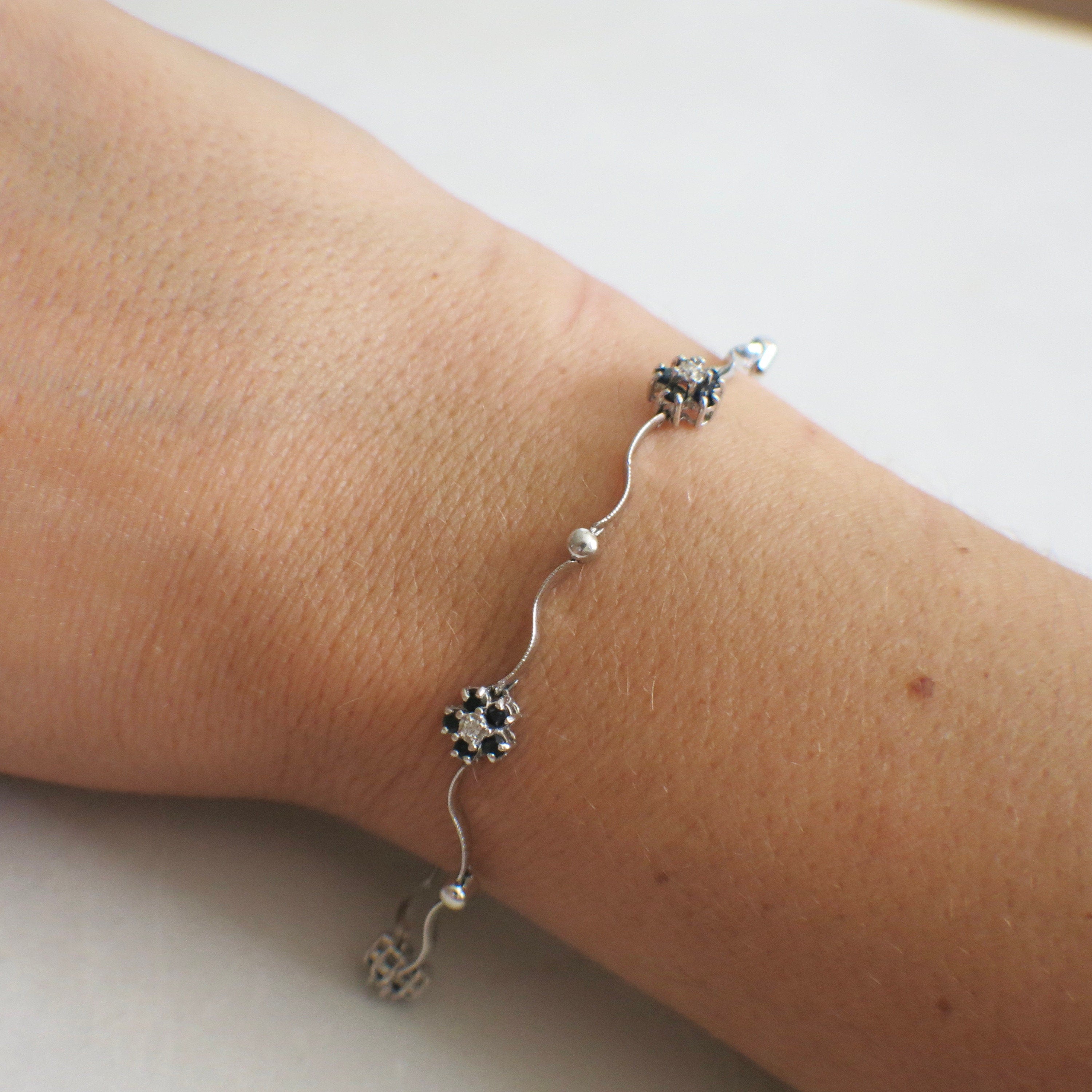 14K white gold sapphire and diamond flower bracelet, 7-inch delicate floral design with intricate gemstone accents.