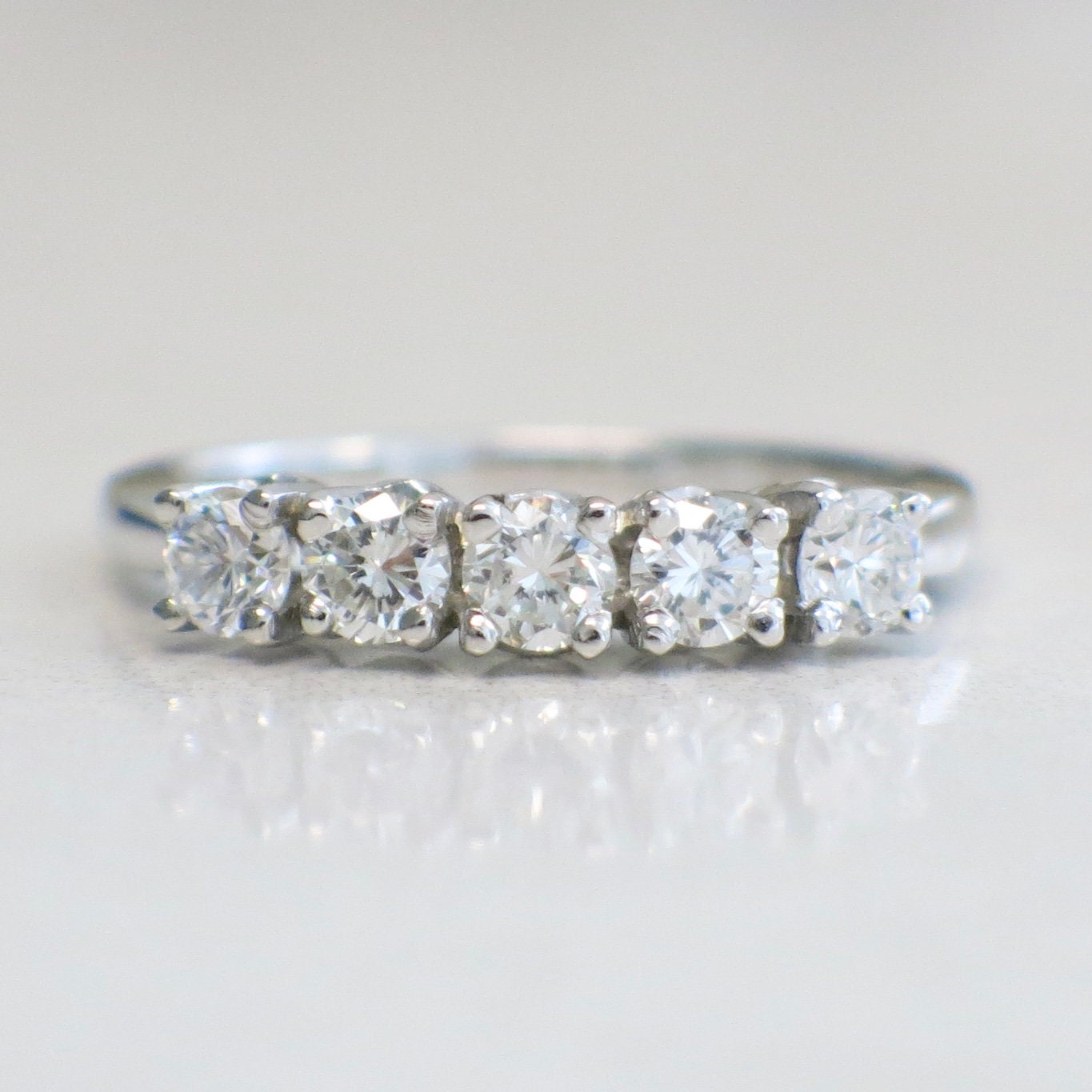 14K white gold five-stone diamond anniversary ring with 0.70 CTW, SI1 F clarity, size 7, featuring sparkling diamonds.