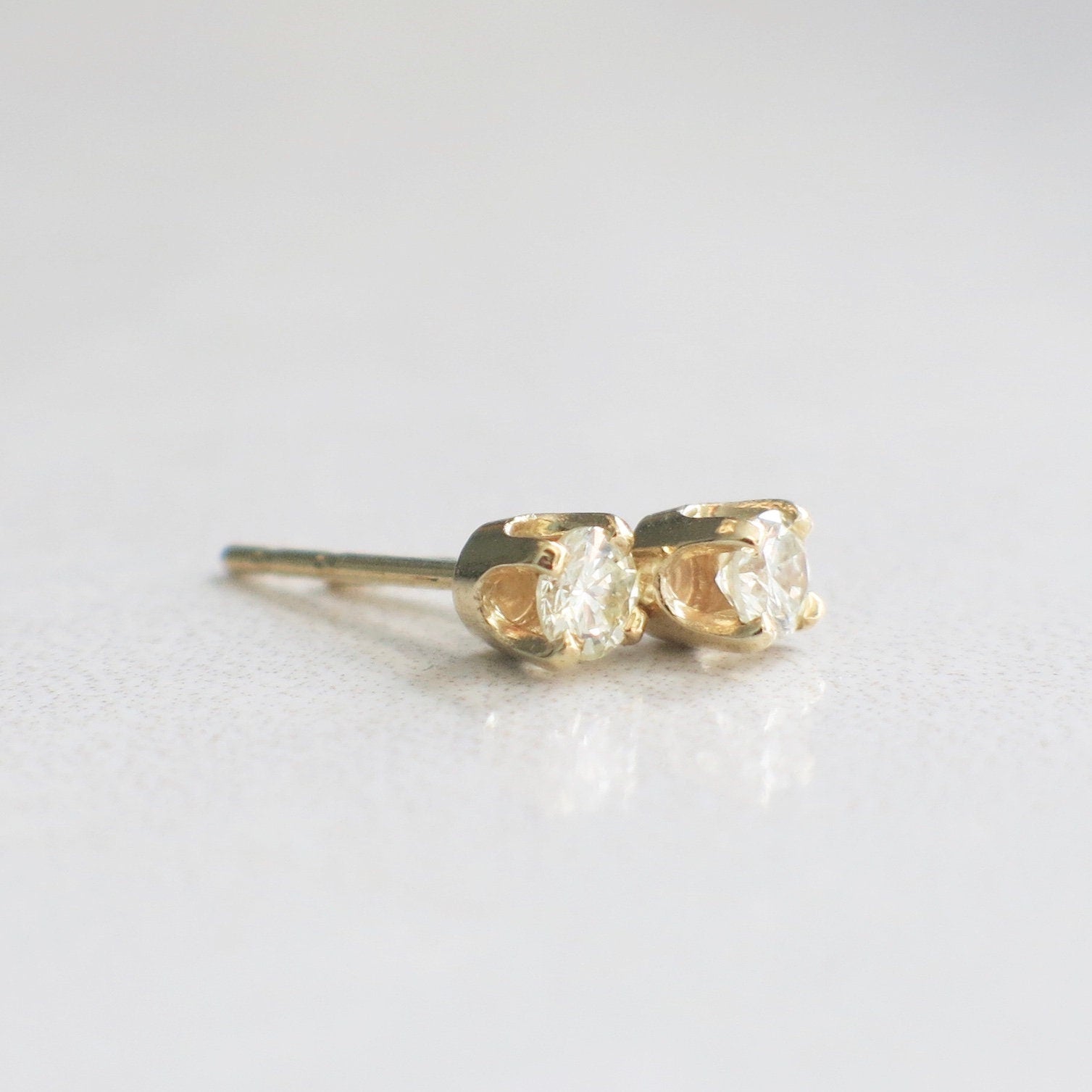 14K yellow gold diamond stud earrings with round brilliant-cut diamonds totaling 0.20 carats, showcasing a classic and elegant design.