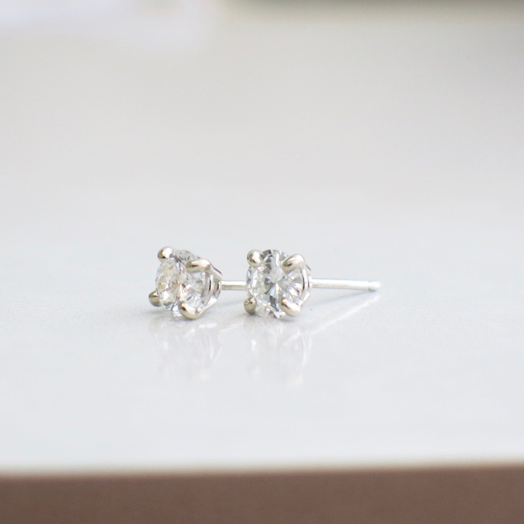 0.80 CT diamond stud earrings in 14K white gold with four-prong setting, SI1 I–J clarity, by Black Market LLC.