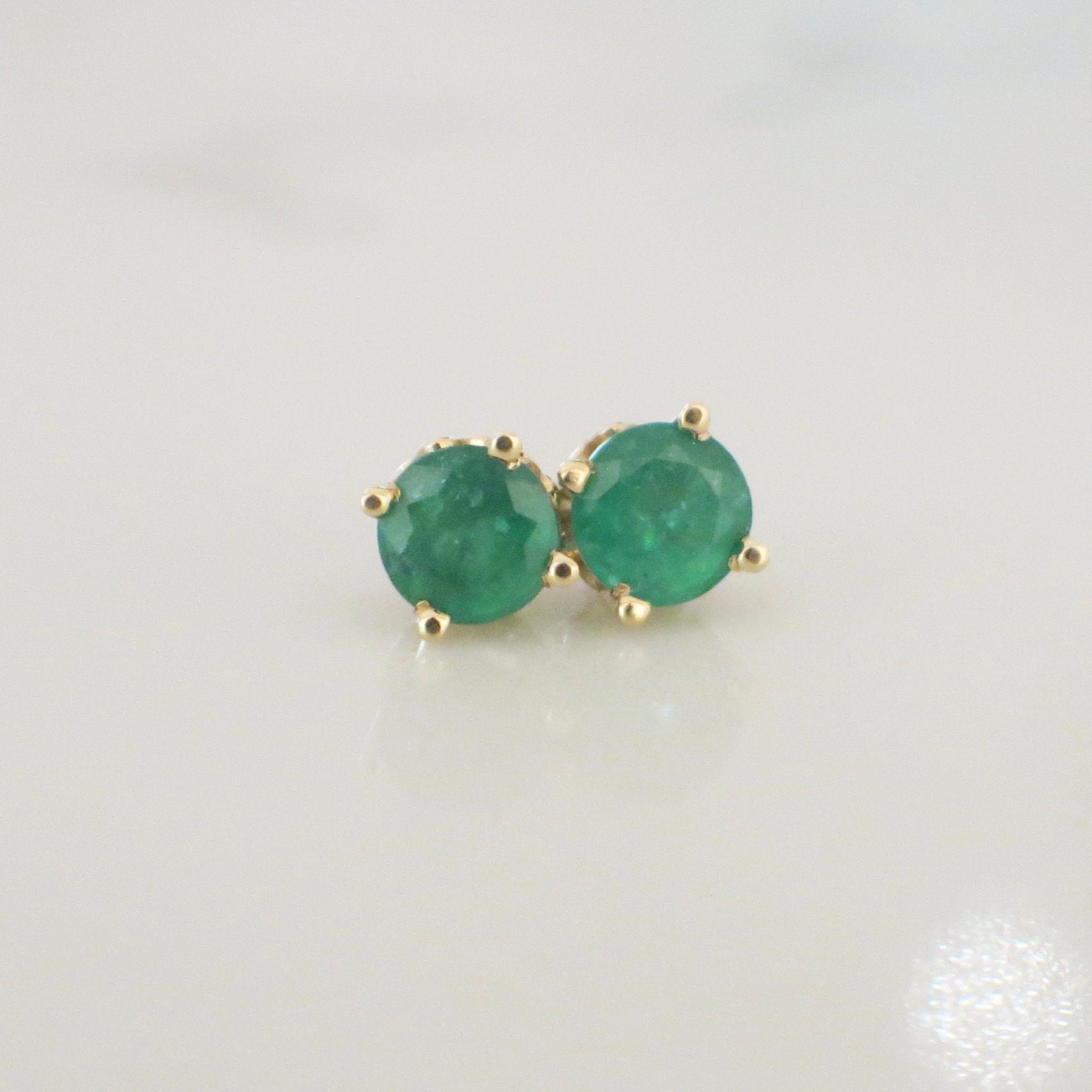 14K yellow gold emerald stud earrings with 1.5 carats of green gemstones in basket setting by Black Market LLC.
