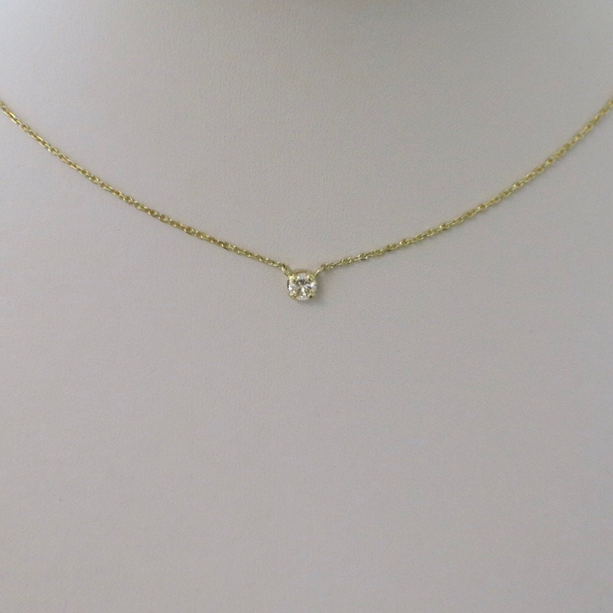 14K gold diamond solitaire necklace with round brilliant pendant, available in 16 or 18 inches, from Black Market LLC.