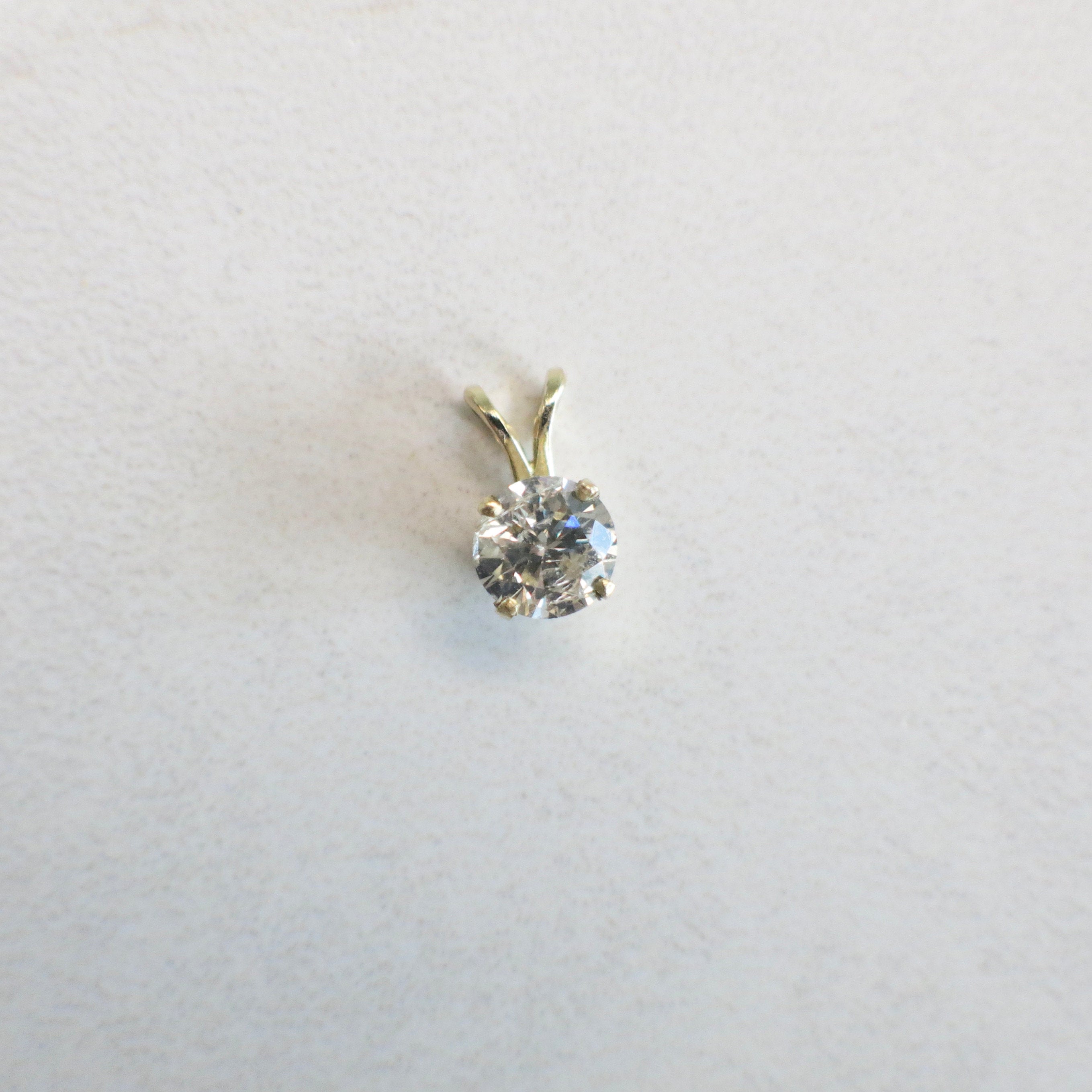 14K yellow gold diamond solitaire pendant necklace with a .65 CTW split shank drop design by Black Market LLC.