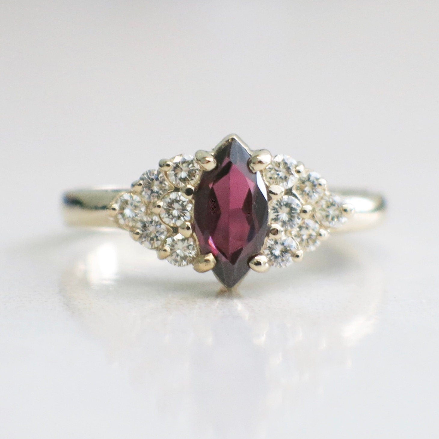 14K gold marquise garnet ring with diamond clusters, vintage style, size 6.5, featuring intricate gold detailing and sparkling gemstones.