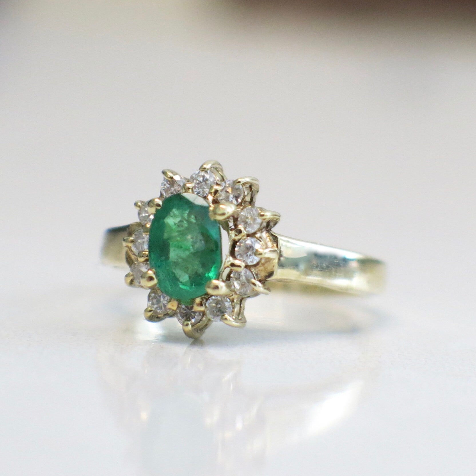 14K yellow gold emerald and diamond halo ring featuring an oval May birthstone, size 3.75, by Black Market LLC.