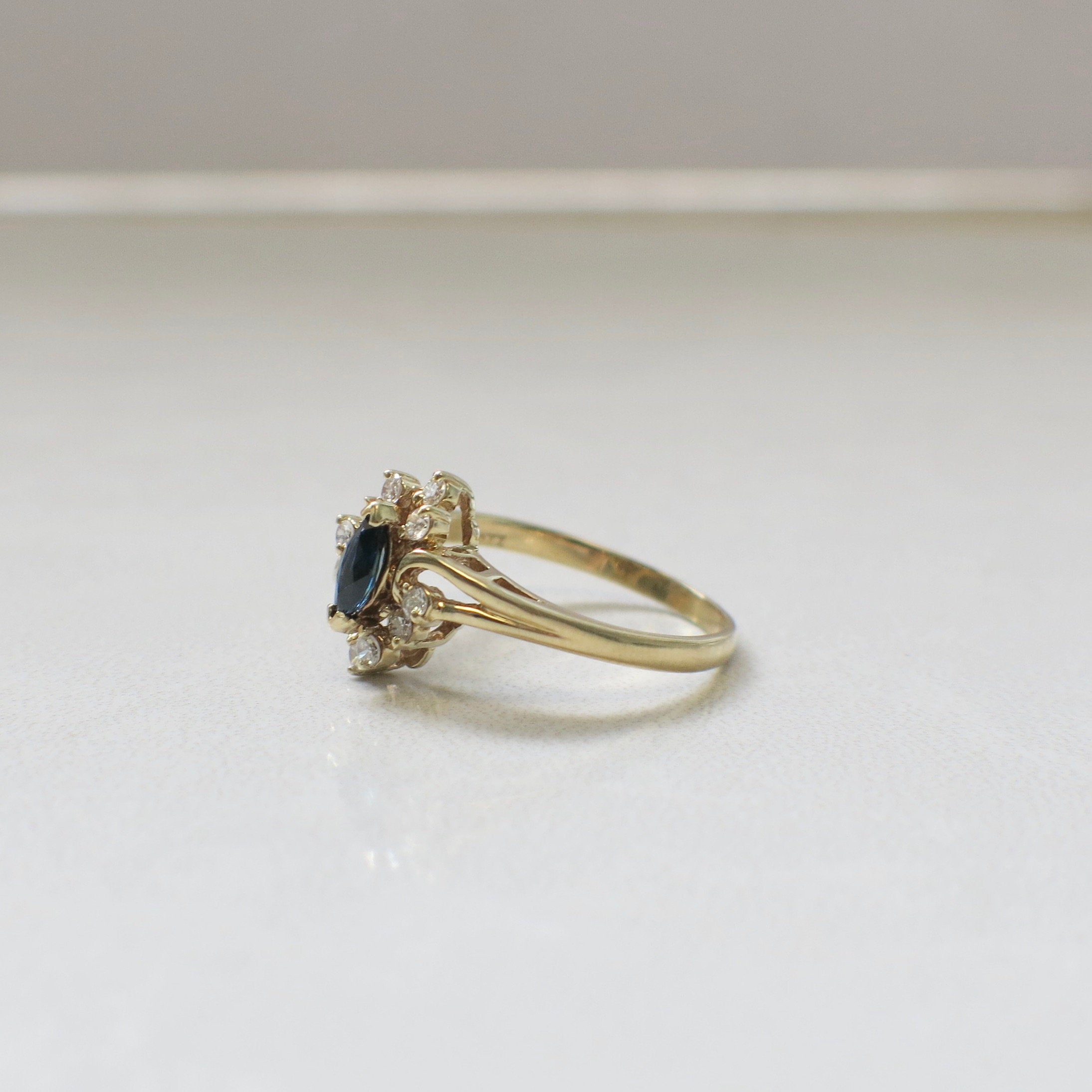 14K yellow gold marquise sapphire and diamond halo ring with vintage floral style, crafted by Black Market LLC.