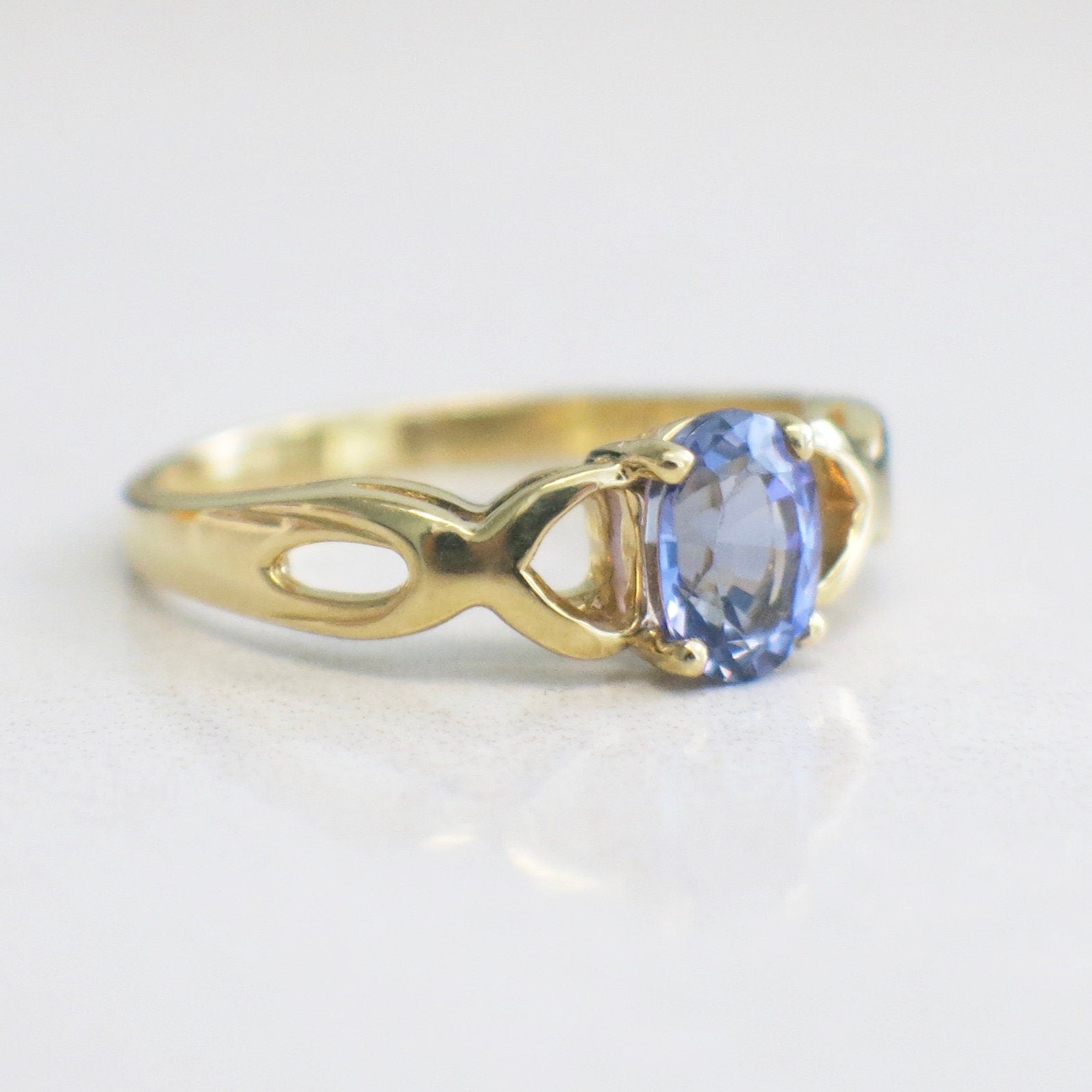 14K yellow gold Tanzanite oval ring with infinity twist band, December birthstone, size 8.5, by Black Market LLC.