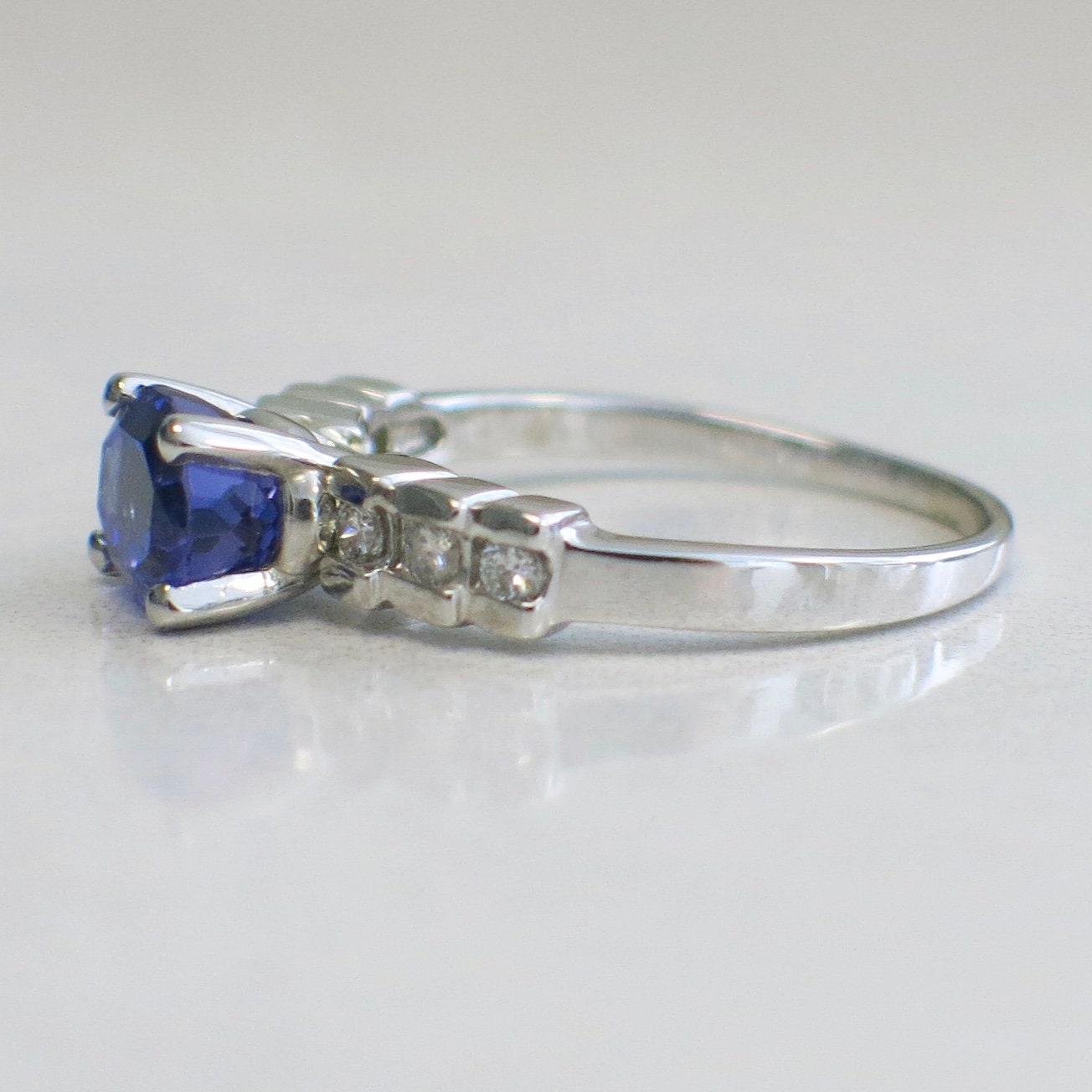 18K white gold oval tanzanite and diamond ring with east-to-west setting, size 8.5, featuring elegant gemstone and diamond accents.