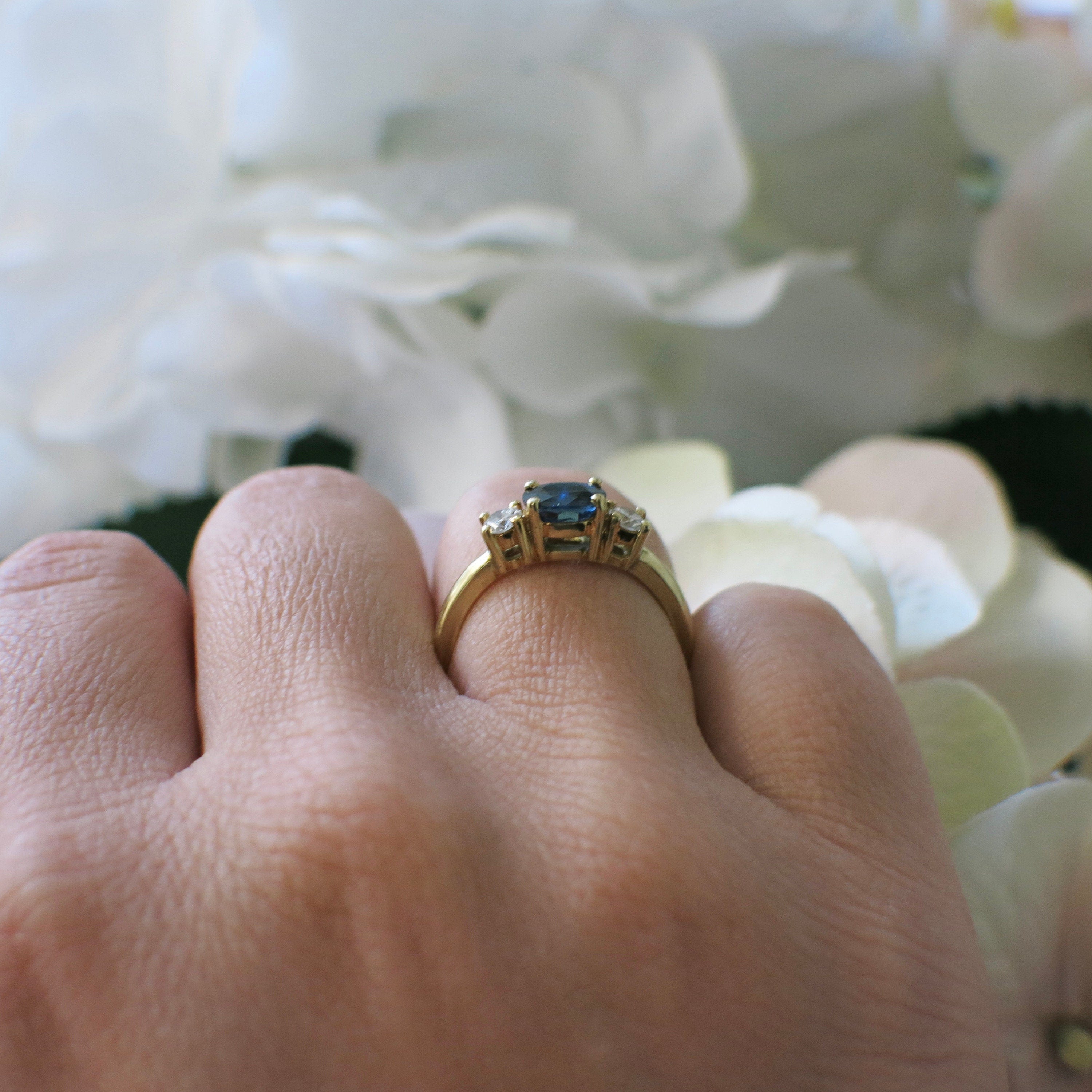 18K yellow gold sapphire and diamond three-stone ring featuring east-west sapphires and sparkling diamonds, elegant engagement ring design.