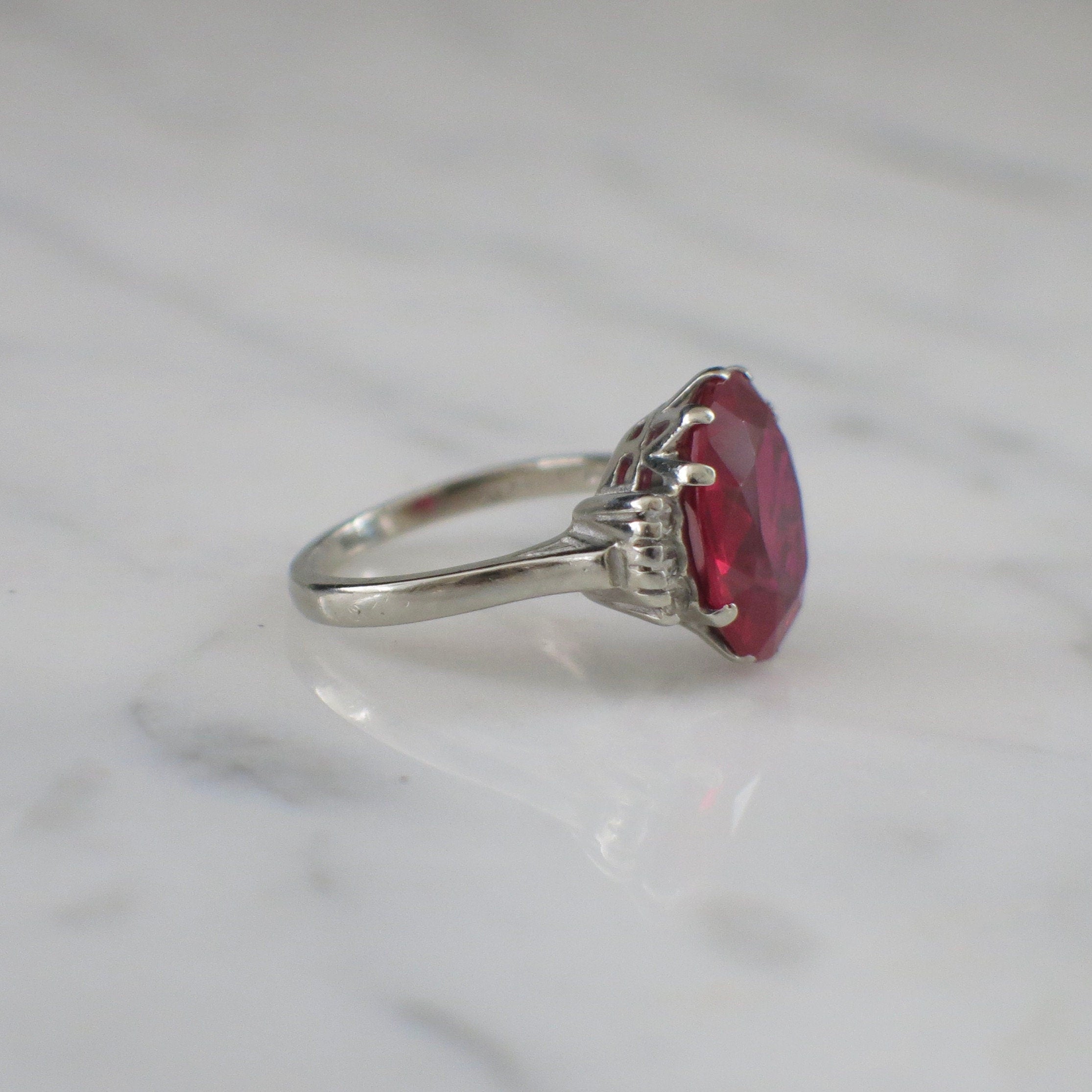 Vintage 10K white gold cocktail ring with oval lab ruby and diamond accents, size 7.25, by Black Market LLC.
