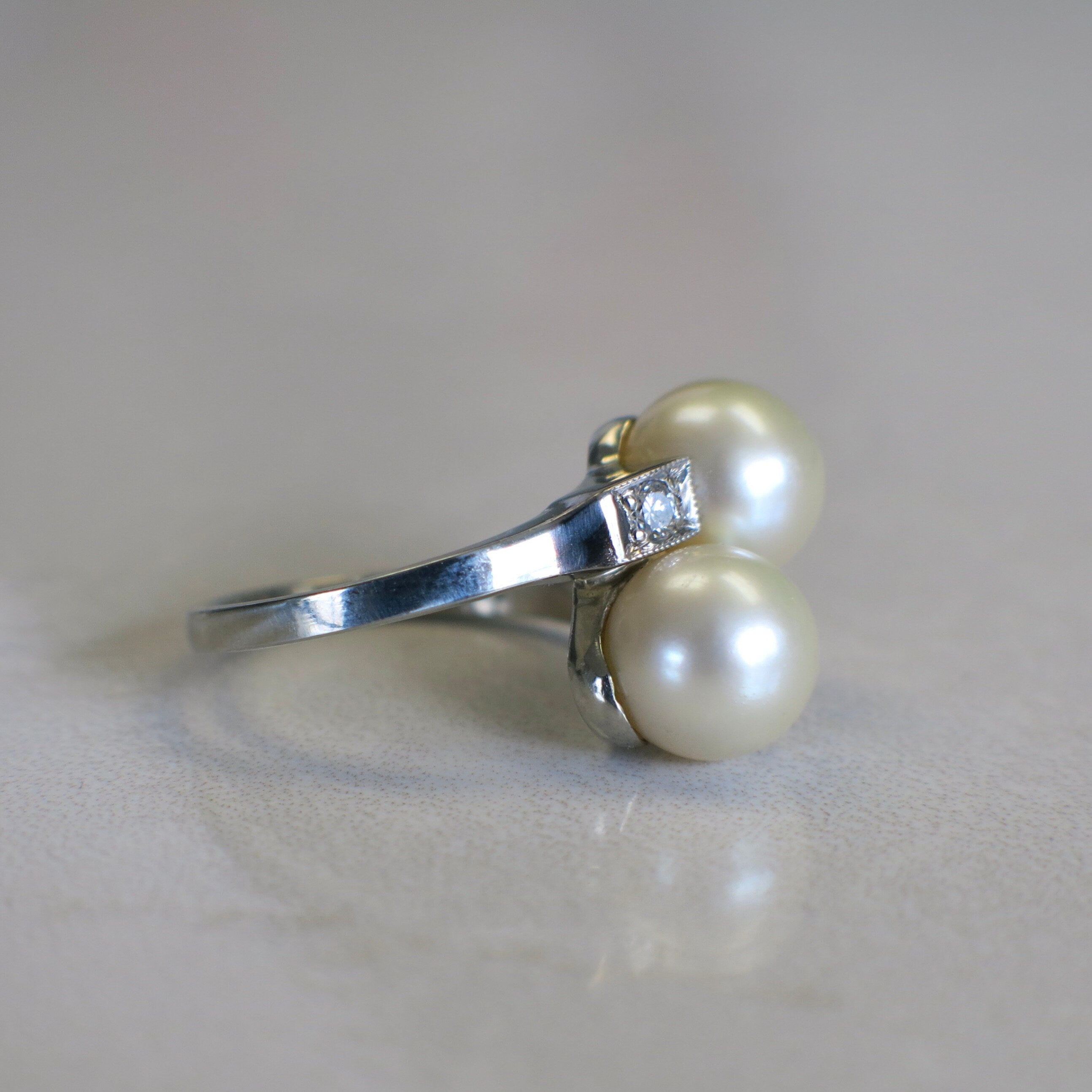 Vintage pearl and diamond ring in 14K white gold with two stones and milgrain detailing, crafted by Black Market LLC.
