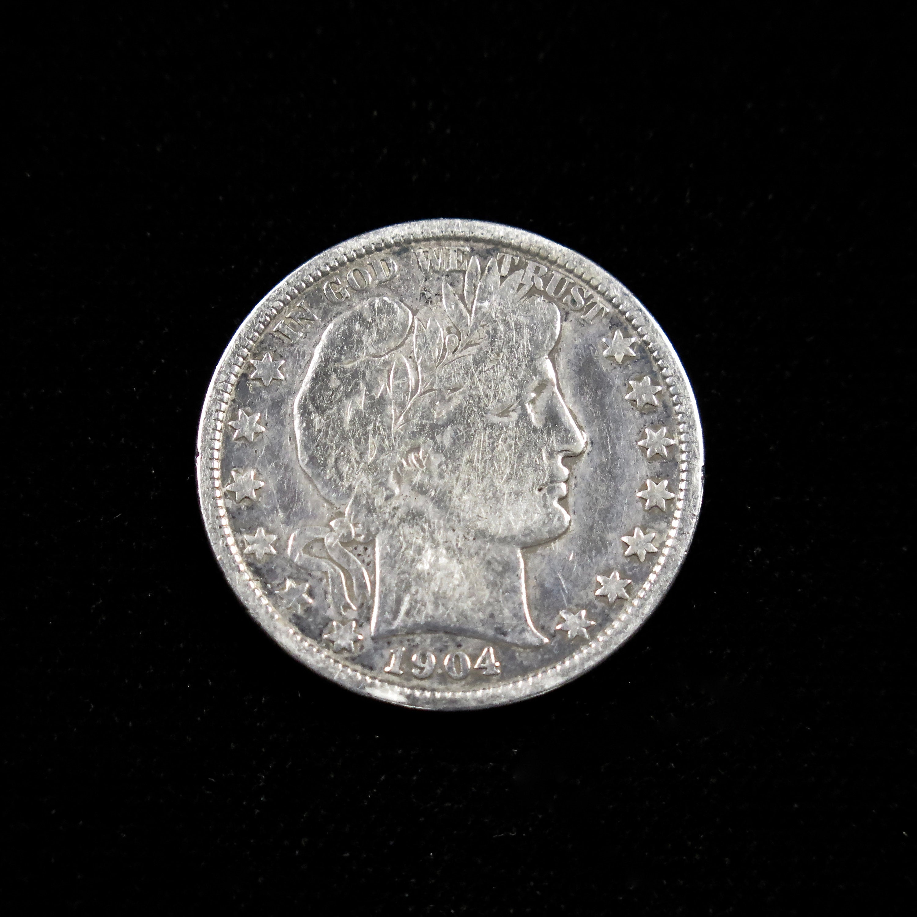 1904 Barber Half Dollar silver coin, fine condition, raw U.S. coin featuring classic turn-of-the-century design.