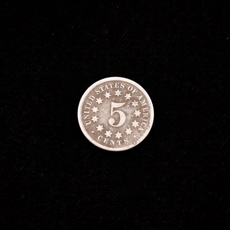 1867 Shield Nickel no rays, good condition, raw U.S. five-cent coin showing the black-market LLC branding and detailed design.