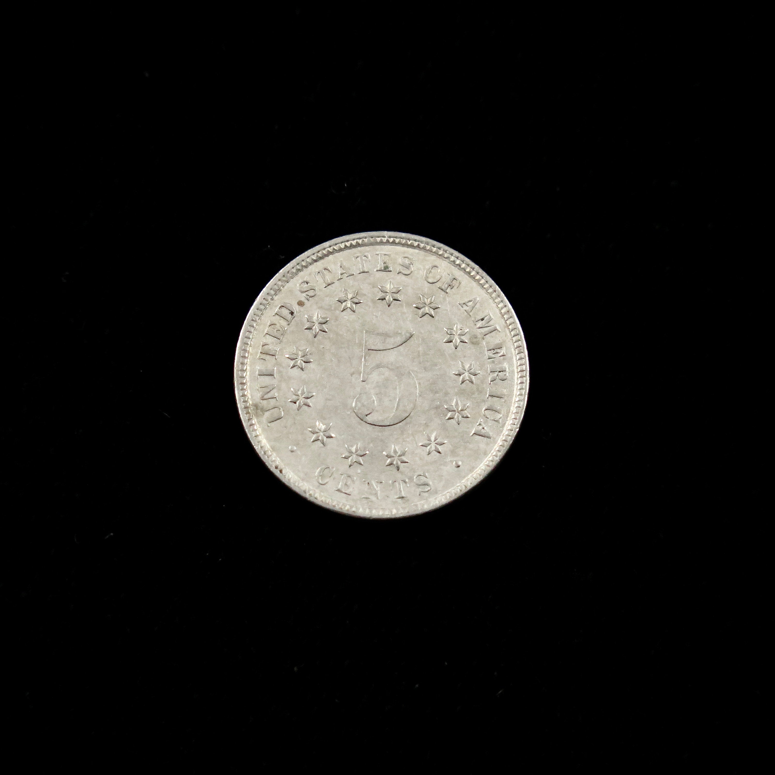 Circulated 1883 Shield Nickel U.S. five-cent coin, final year of issue, raw condition, featuring classic shield design.