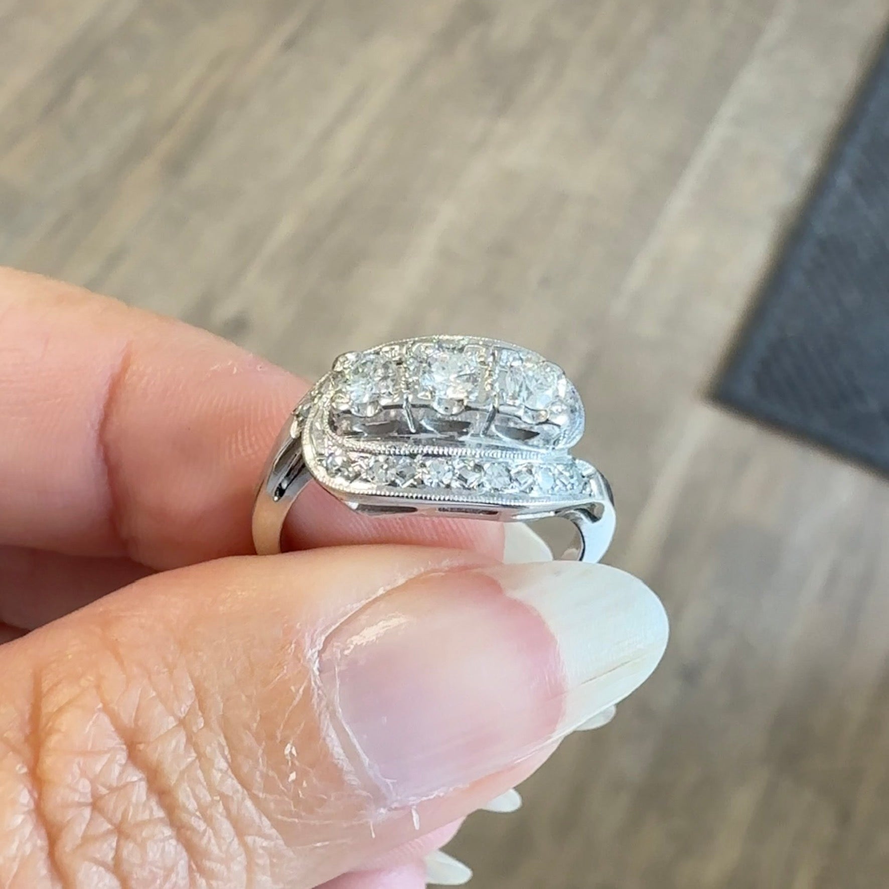 Vintage Art Deco 14K white gold three-stone diamond ring with milgrain detail, ideal for engagement or cocktail occasions.