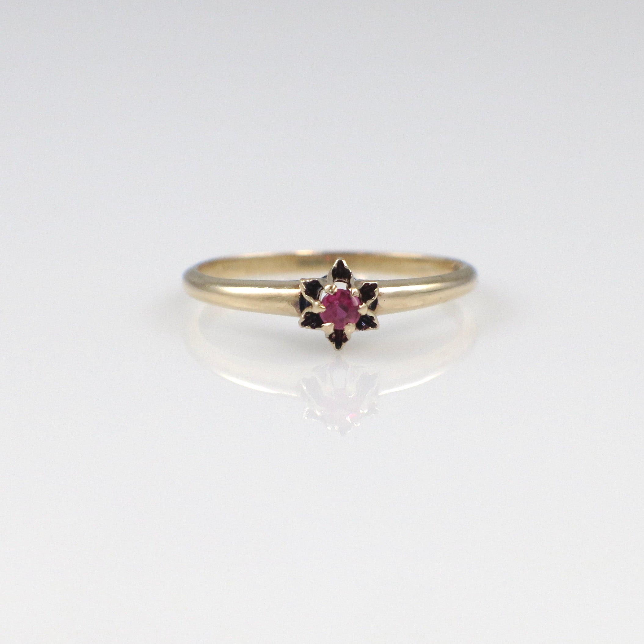 Gold ring with a pink gemstone on a white background