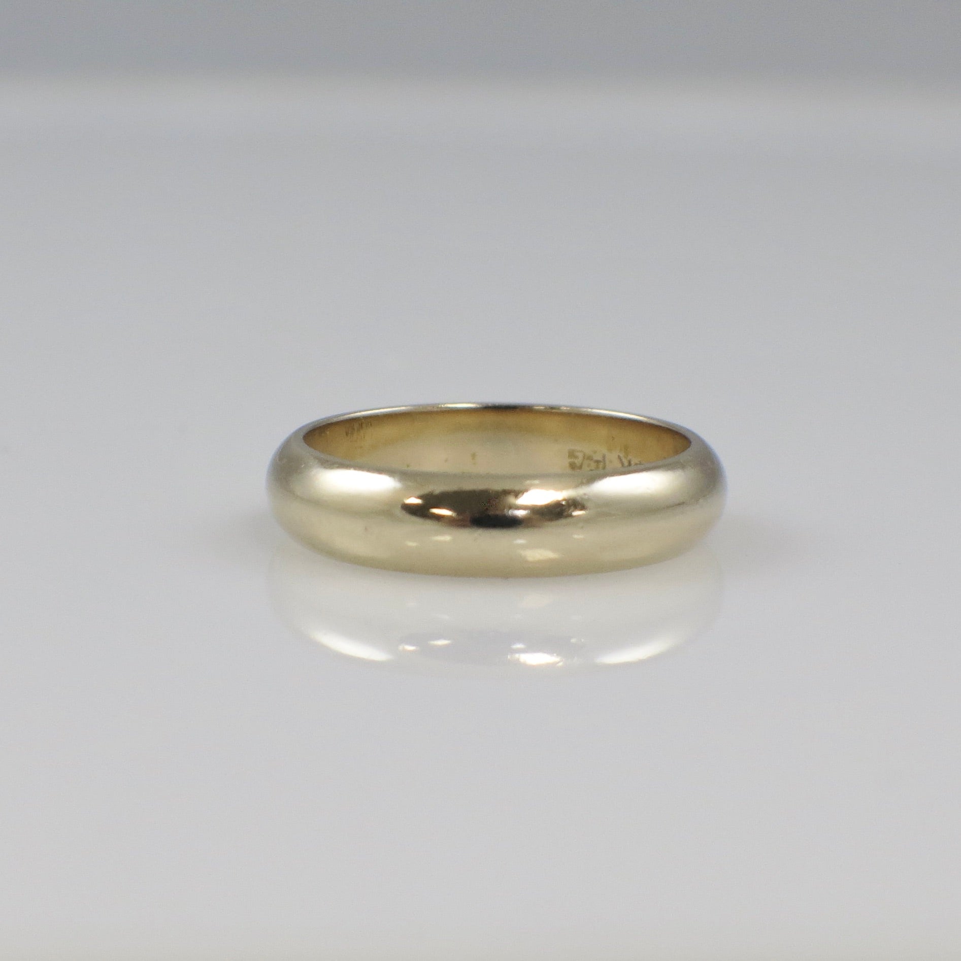14K yellow gold men's wedding band, 5mm wide in size 8.75, smooth polished finish, from Black Market LLC.