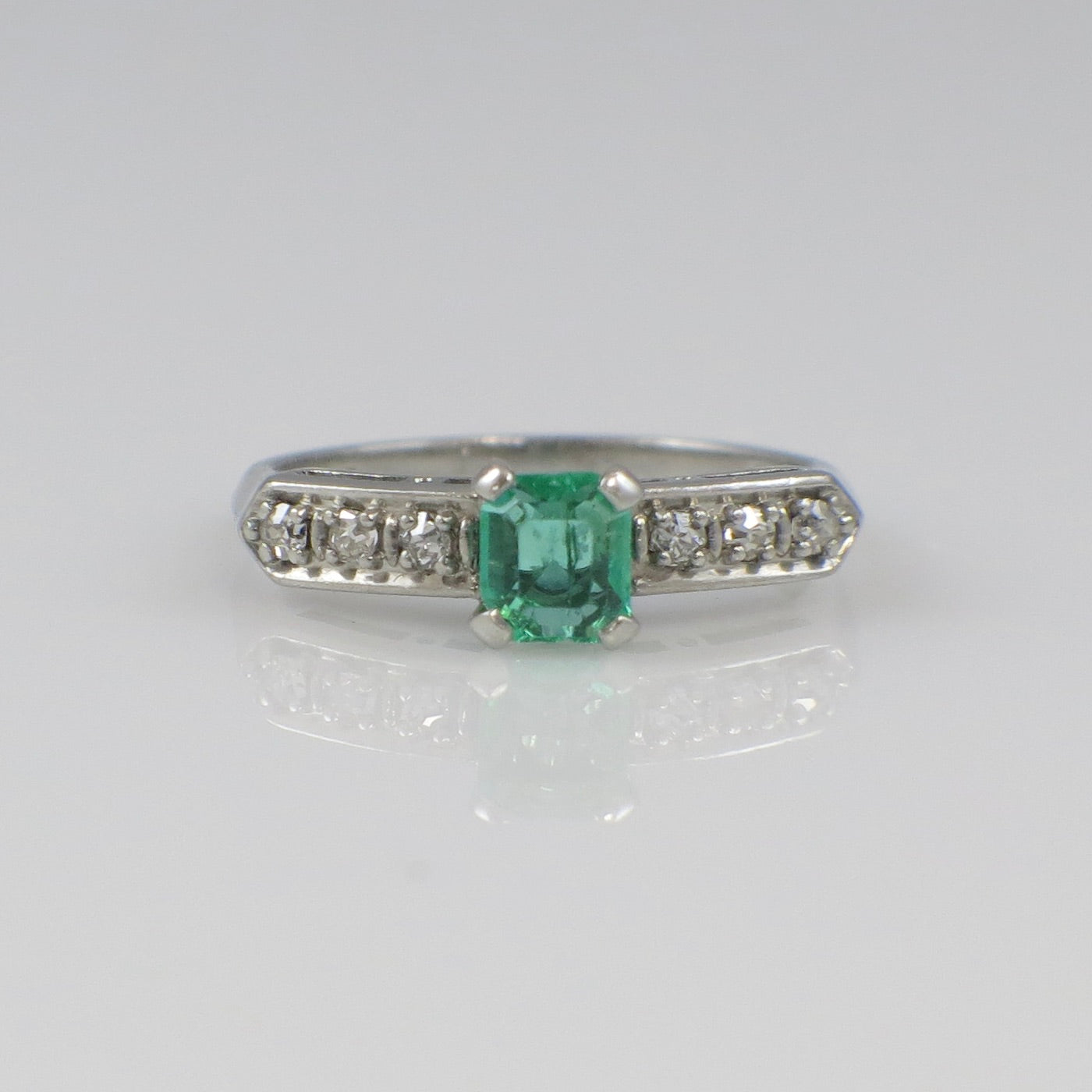 Vintage Art Deco emerald platinum ring with diamond accents, circa 1930s, showcasing intricate design and elegant craftsmanship.