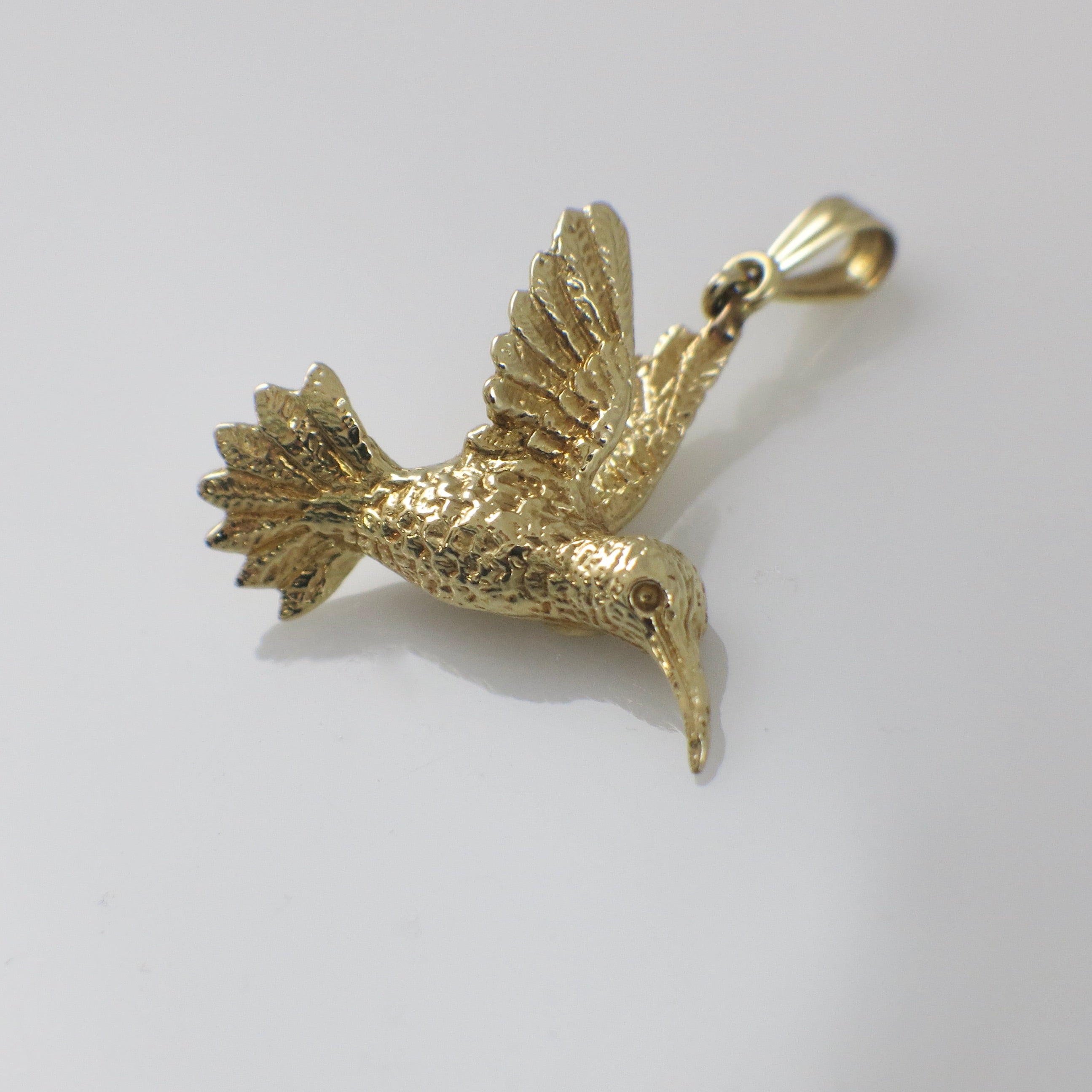 14K yellow gold hummingbird charm pendant with detailed bird design, crafted by Black Market LLC.