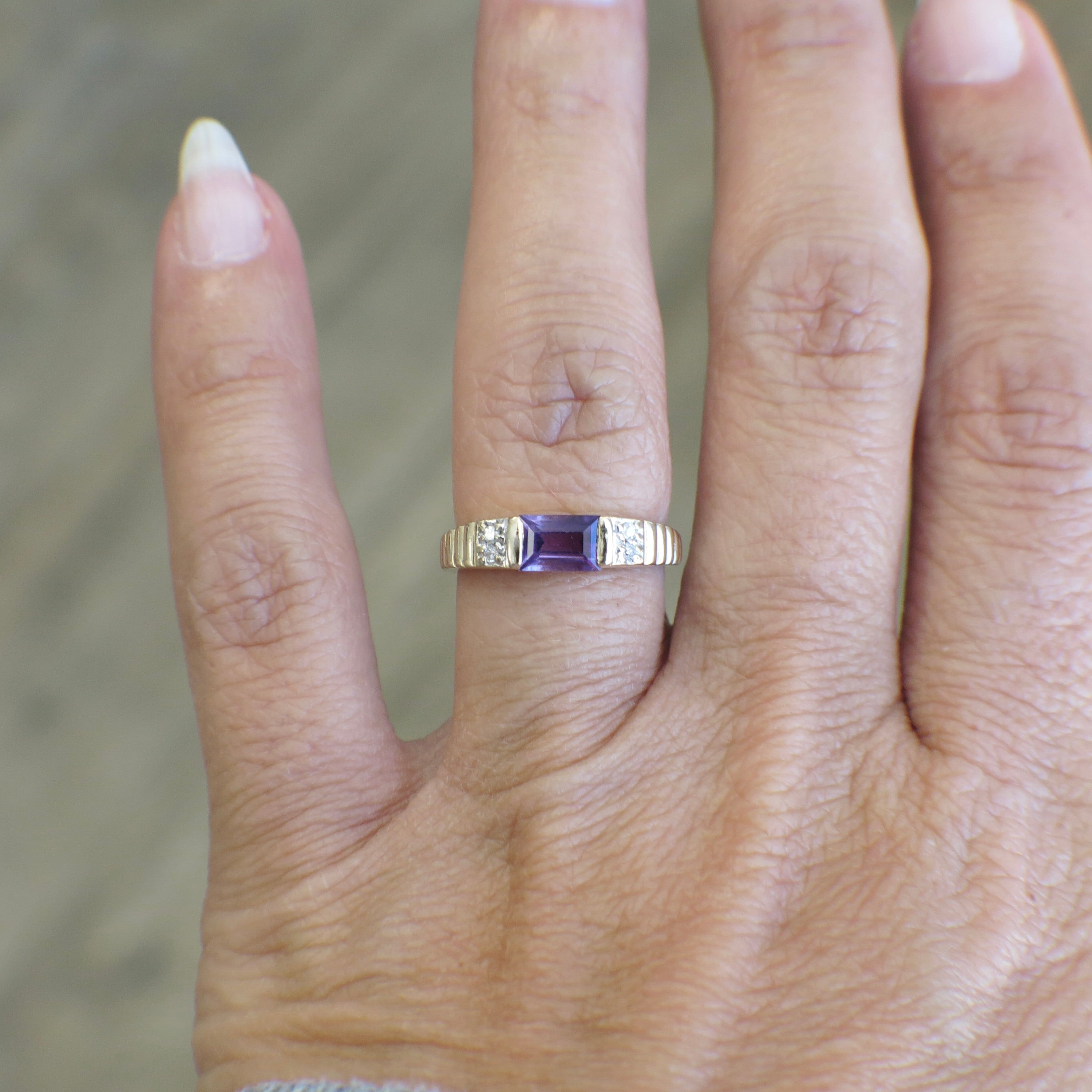 Yellow gold amethyst ring with emerald cut gemstone and diamond accents, crafted by Black Market LLC.
