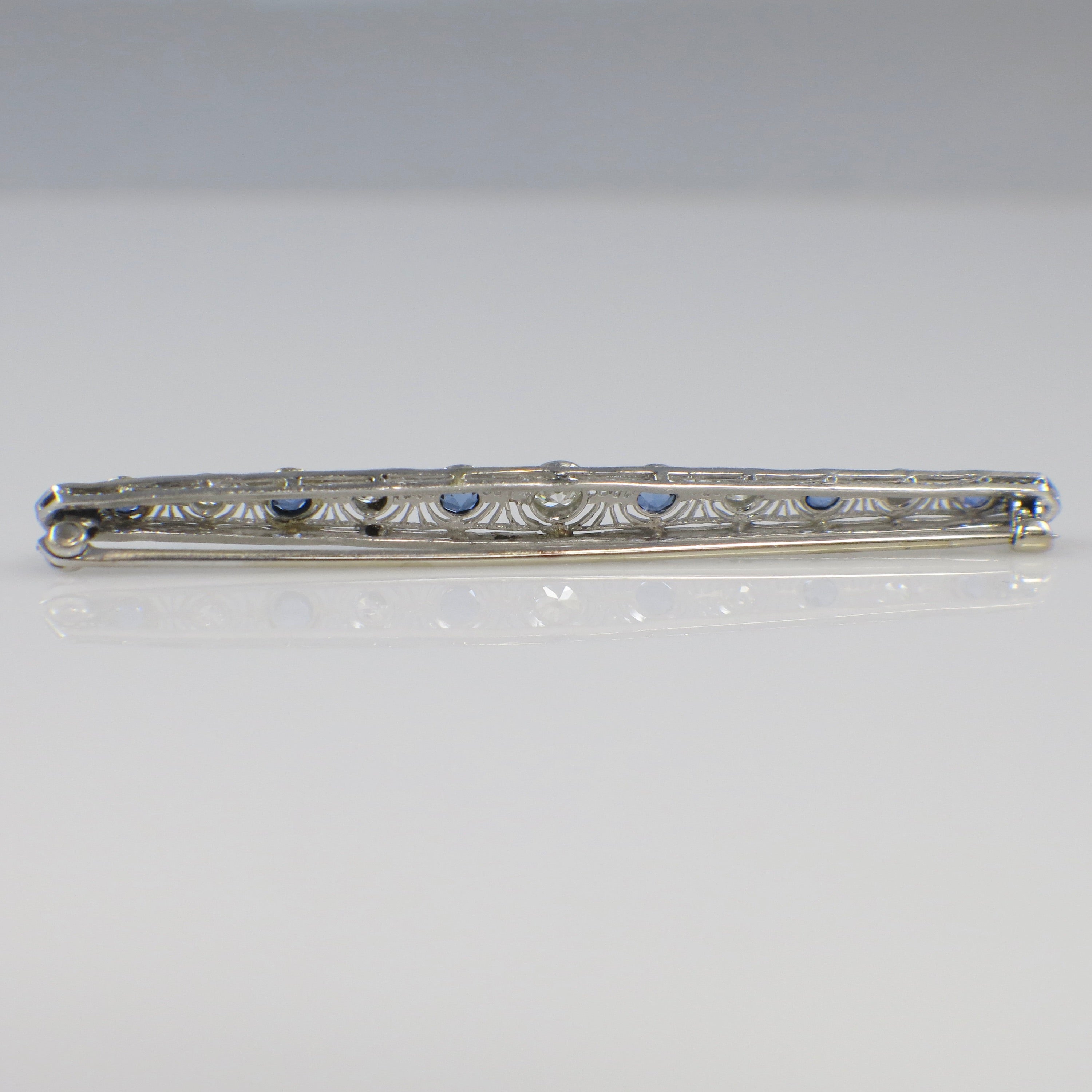 Art Deco 14K white gold diamond and sapphire pin with intricate design, featuring sparkling gemstones and elegant craftsmanship.