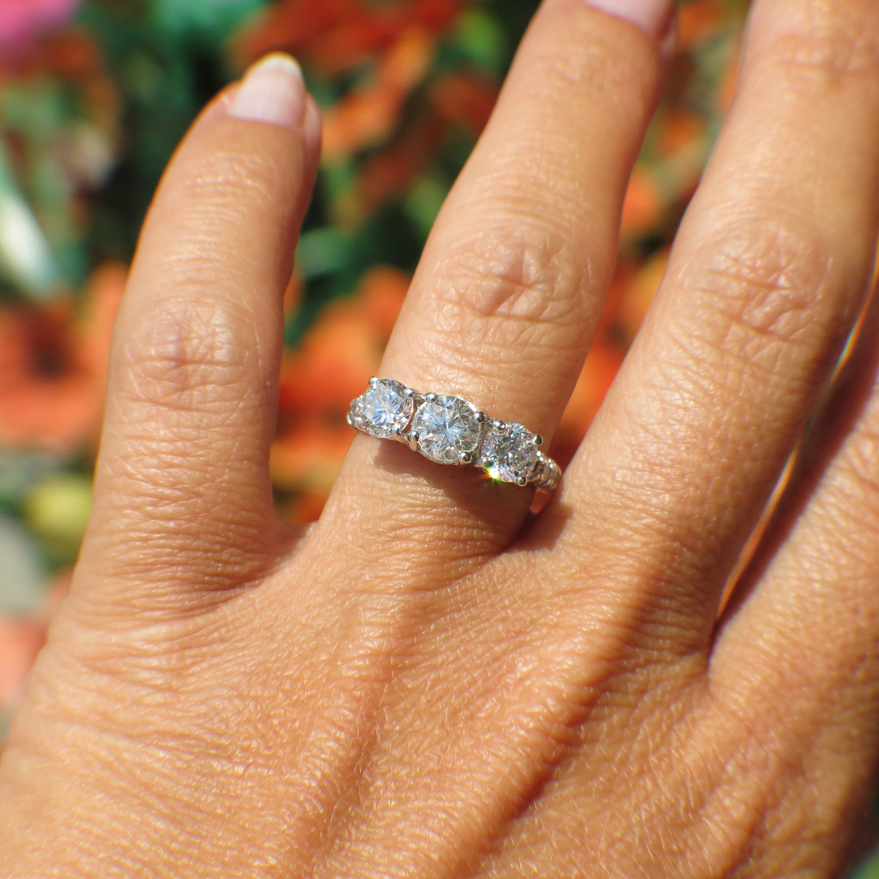 Vintage 18K white gold three-stone diamond engagement ring with 1.92 CTW, featuring a classic design and sparkling diamonds.