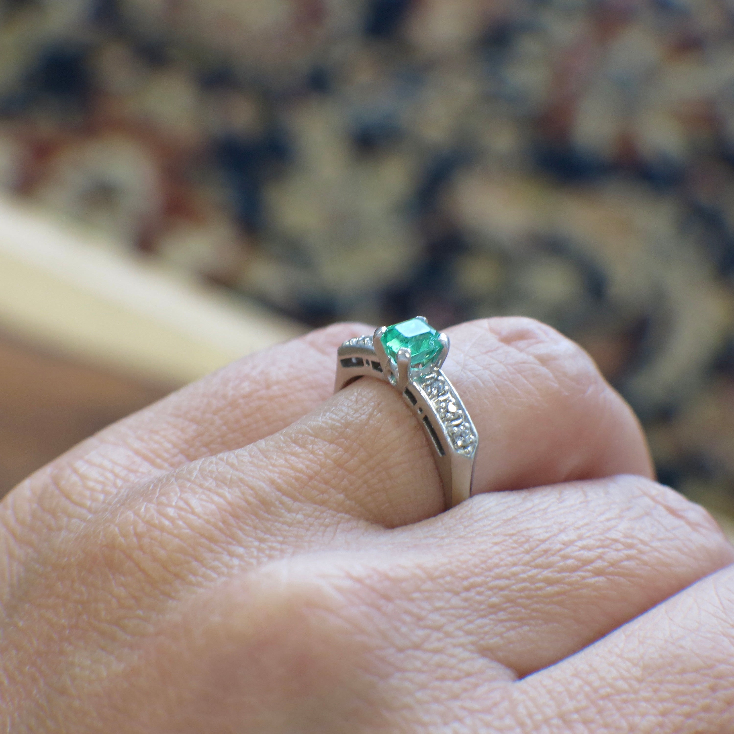 Vintage Art Deco emerald ring in platinum with diamond accents from the 1930s, featuring intricate design and fine craftsmanship.