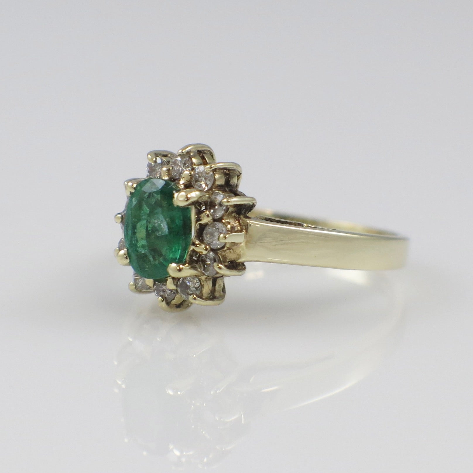 Vintage 14K yellow gold emerald and diamond halo ring with intricate design, from Black Market LLC.