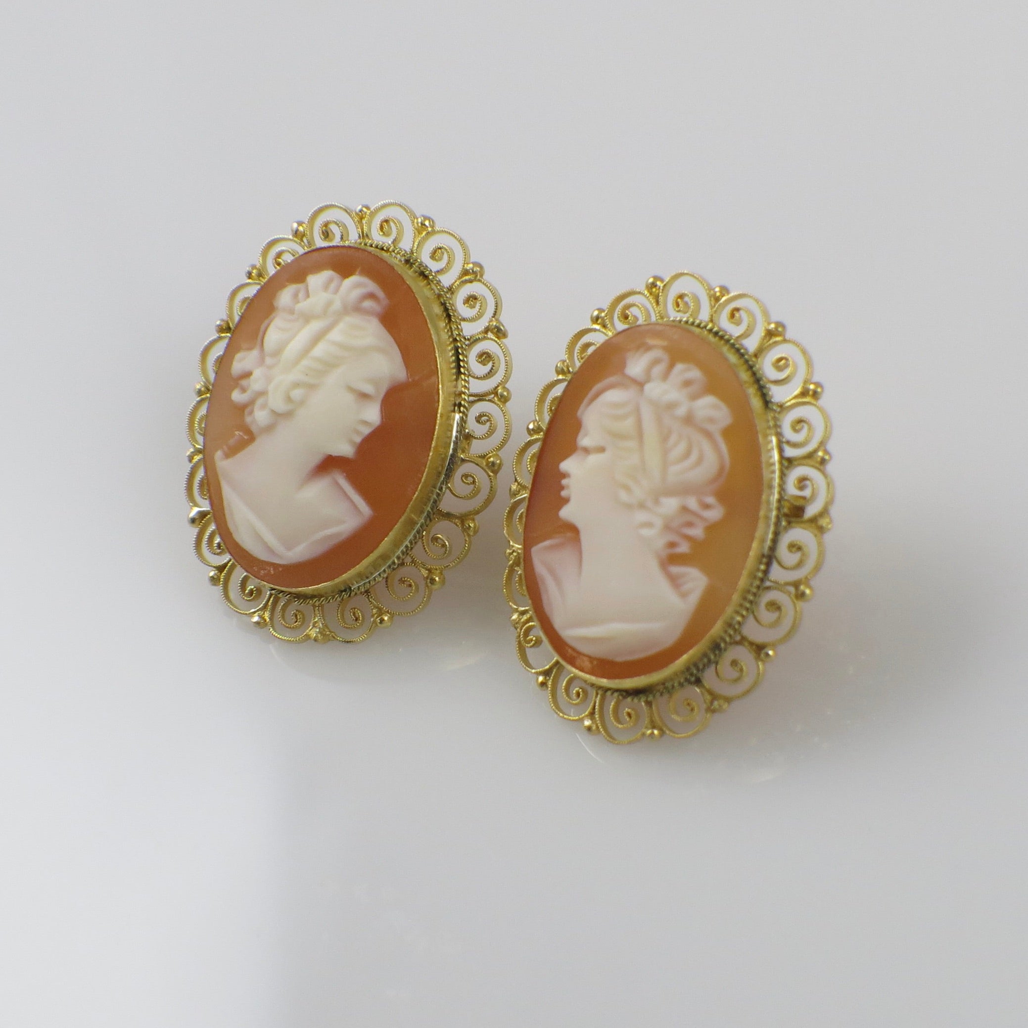 Italian hand-carved shell cameo earrings with gold filigree setting featuring intricate detailing and vintage elegance.