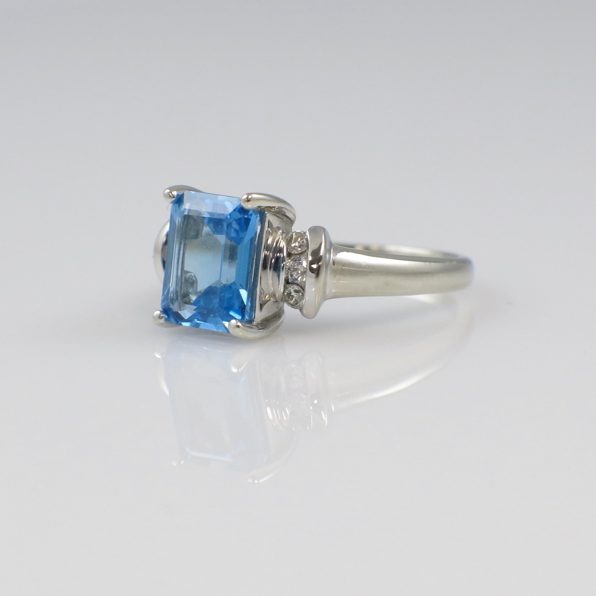 14K white gold blue topaz ring with diamond accents, emerald cut, designed by Black Market LLC.