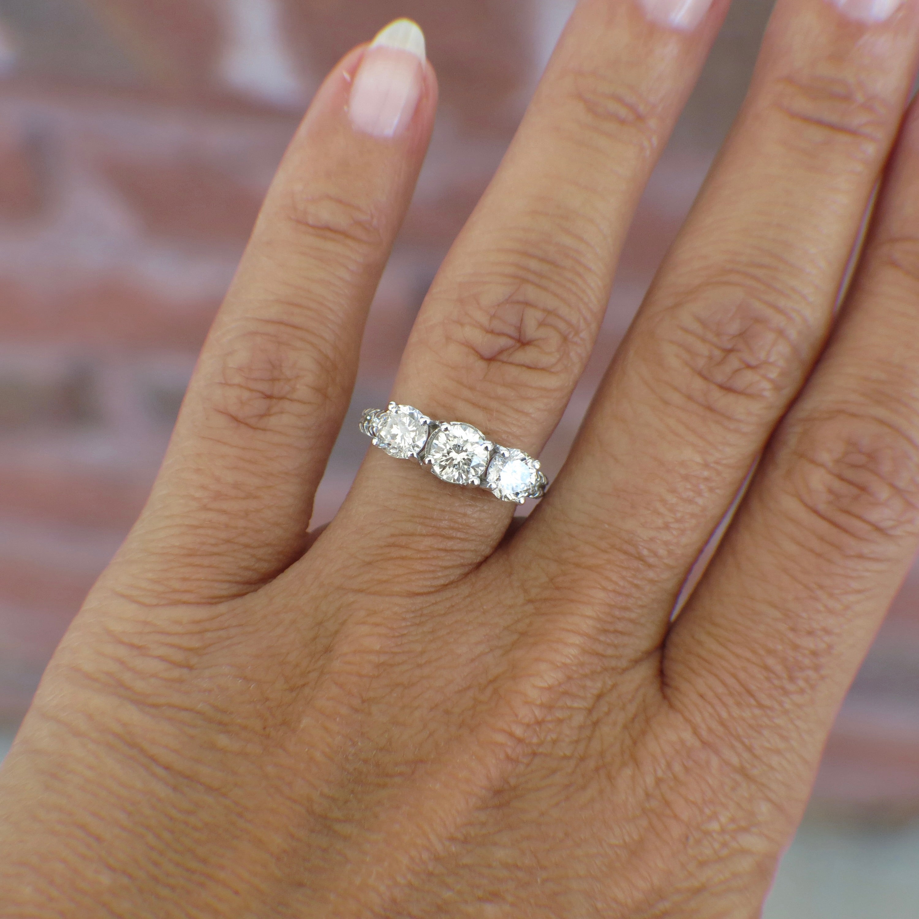 Vintage 18K white gold three stone diamond engagement ring with 1.92 CTW from Lillian James Bridal, featuring intricate detailing.