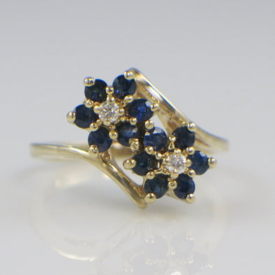 Gold ring with blue gemstones on a light gray background